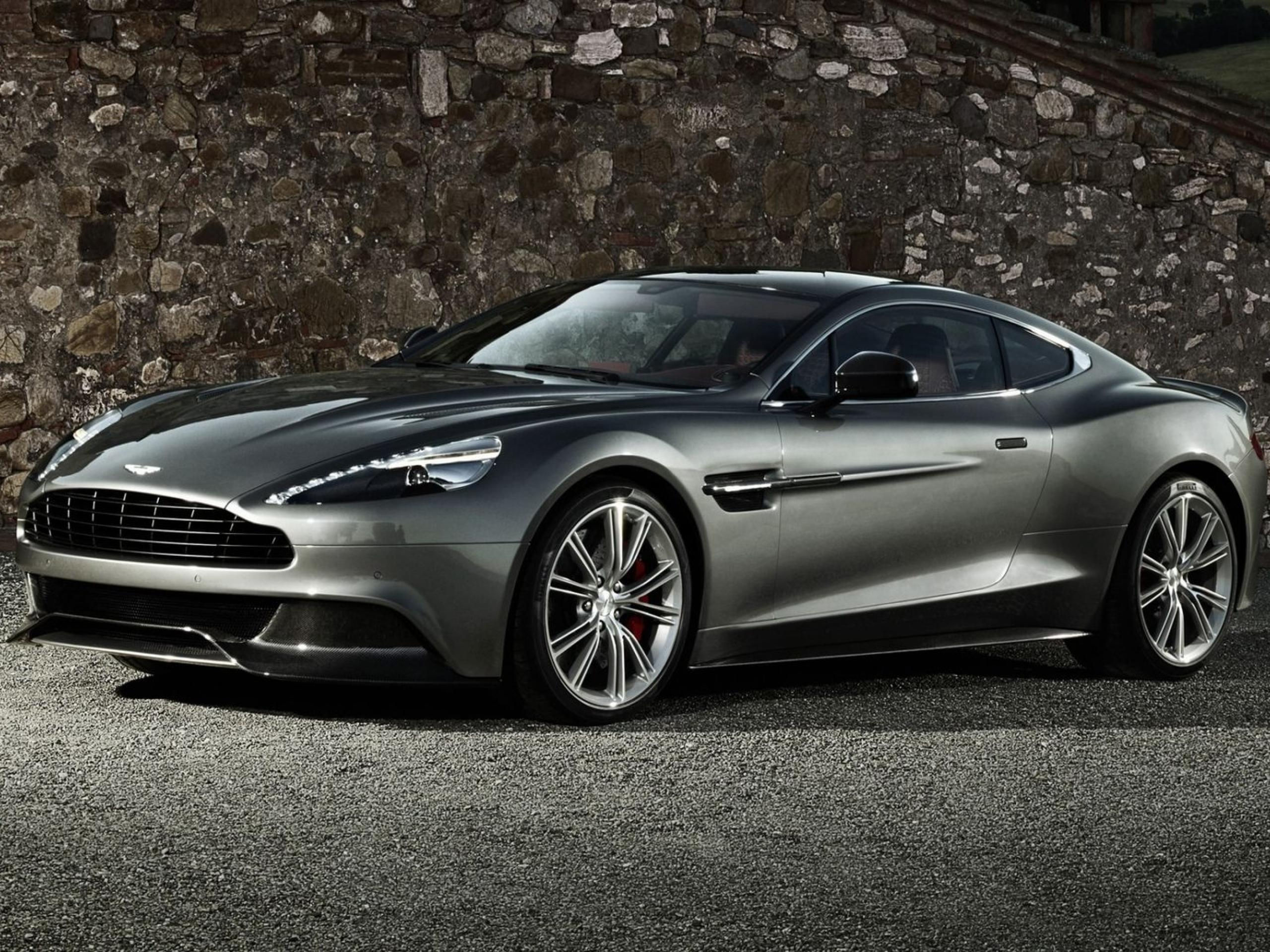 Wallpaper #0nP5hY4BFI5NbQksux4v54 A Sleek Silver Aston Martin Vanquish Parked in Front of a Stone Wall