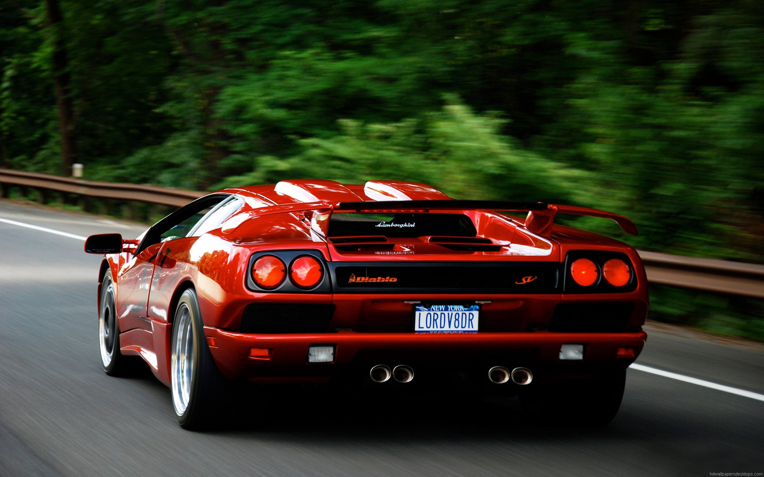 Wallpaper #6HOoiI4BFI5NbQksoSFu29 A Red Lamborghini Diablo SV Driving on a Winding Road