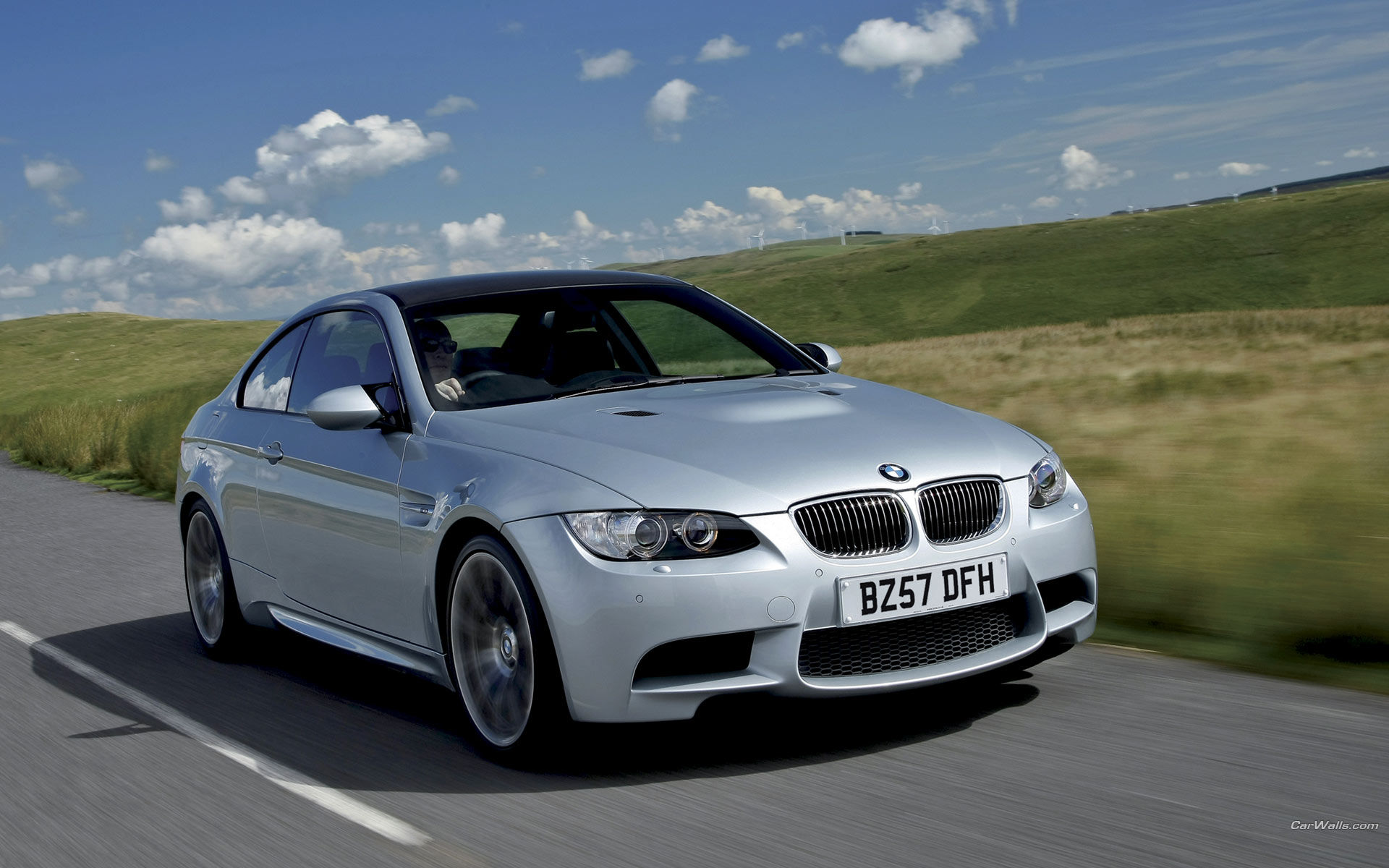 Wallpaper #w0Xoko4B7YBJg1BVD55I16 A Silver BMW M3 E92 Coupe Drives on a Country Road
