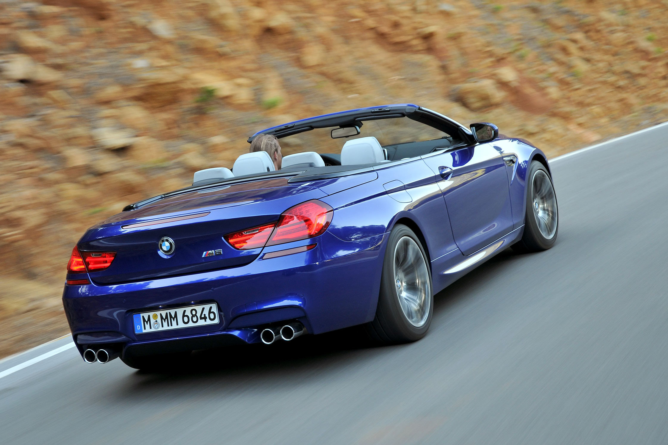 Wallpaper #VkVolo4B7YBJg1BVLqAC13 A Blue BMW M6 Convertible Driving on a Winding Road