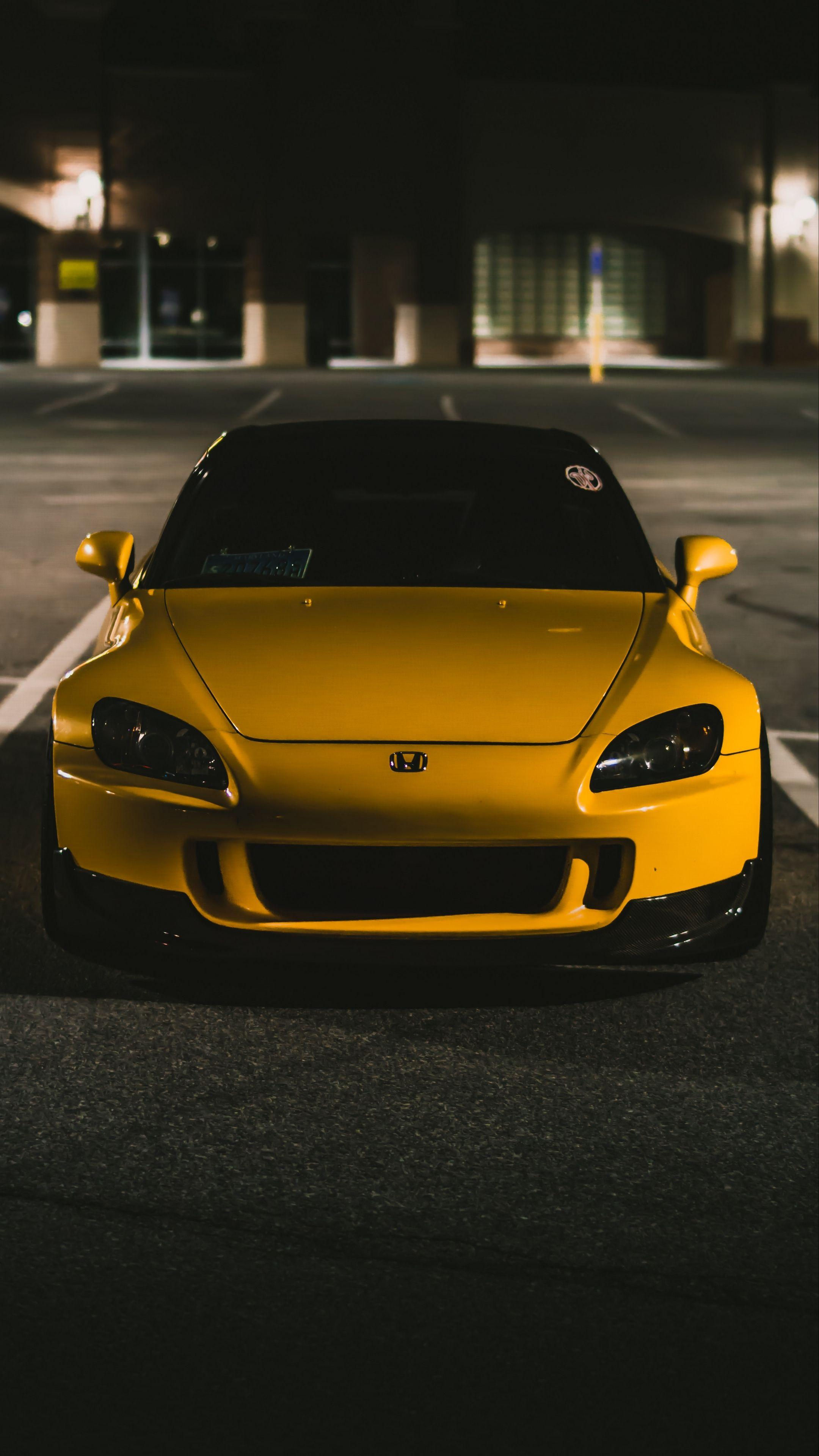 Wallpaper #r0U0l44B7YBJg1BVZKDq26 A Yellow Sports Car Parked in a Parking Lot at Night