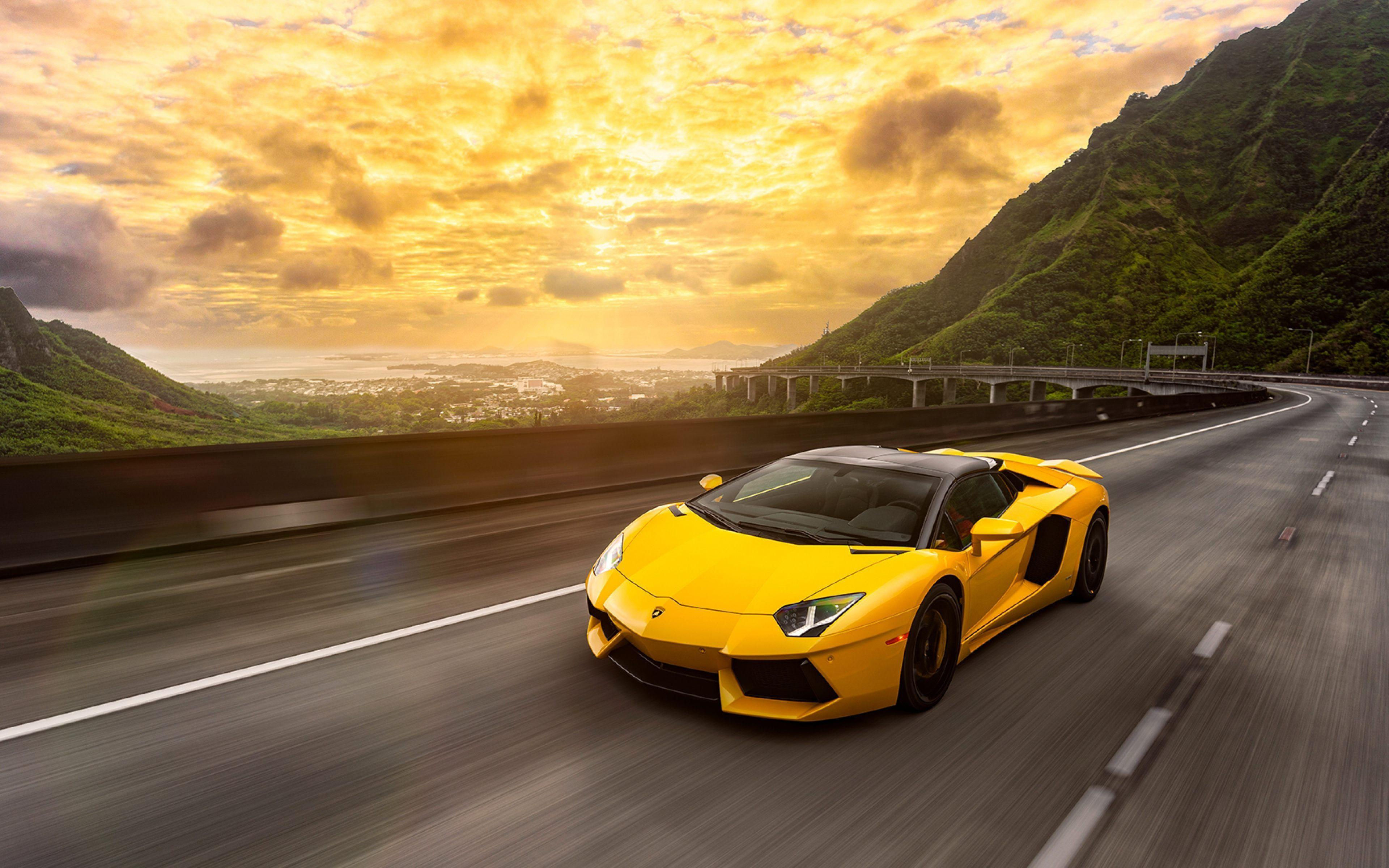 Wallpaper #-nP_iI4BFI5NbQks_iGJ0 A Yellow Lamborghini Aventador SVJ Roadster Speeds Along a Coastal Highway