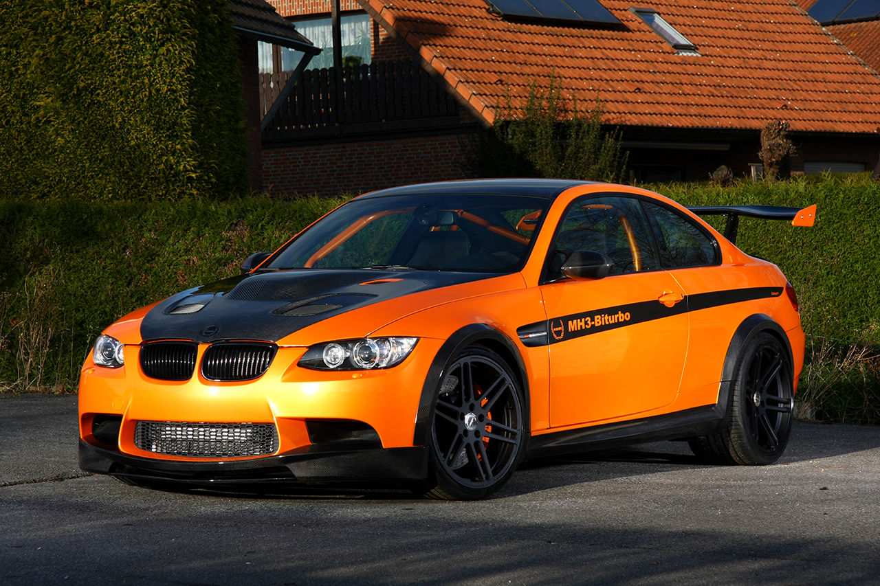 Wallpaper #7xWWsI4BmMigT4UnT1DQ8 A Bright Orange BMW Parked on a Suburban Street