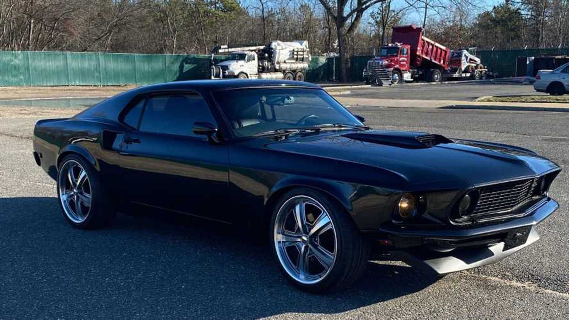 Wallpaper #vUUBm44B7YBJg1BVD6GI34 A Black Ford Mustang Mach 1 Parked in a Parking Lot