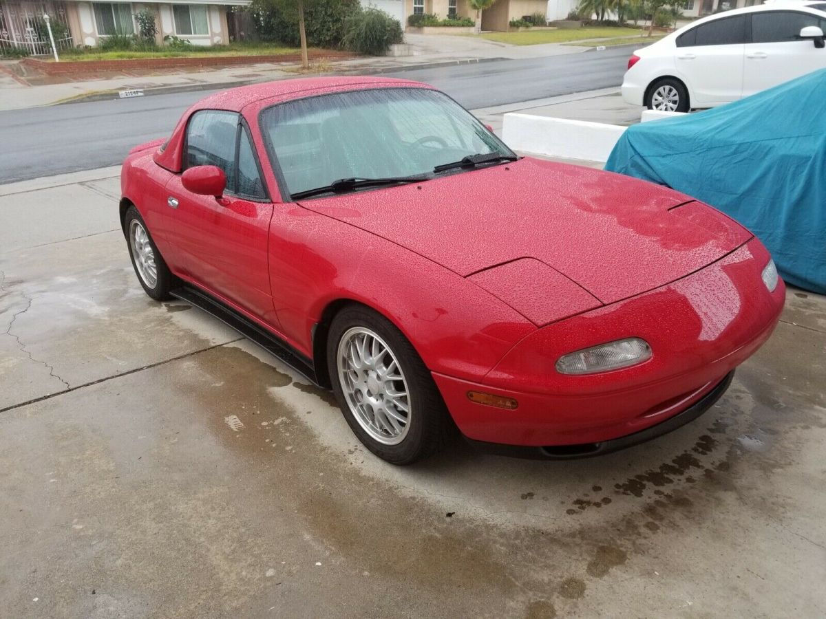 Wallpaper #TnOUg44BFI5NbQksURuh27 A Red Mazda Miata Parked in the Rain