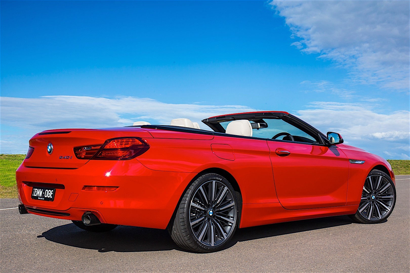 Wallpaper #VkVolo4B7YBJg1BVLqAC16 A Red BMW 6 Series Convertible Driving on a Coastal Road with the Top Down