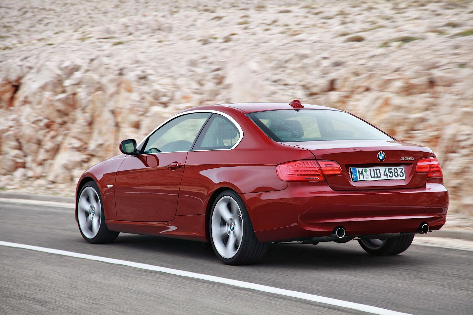Wallpaper #lUW_oo4B7YBJg1BVBqSA8 A Red BMW 335i Coupe Drives on a Winding Road