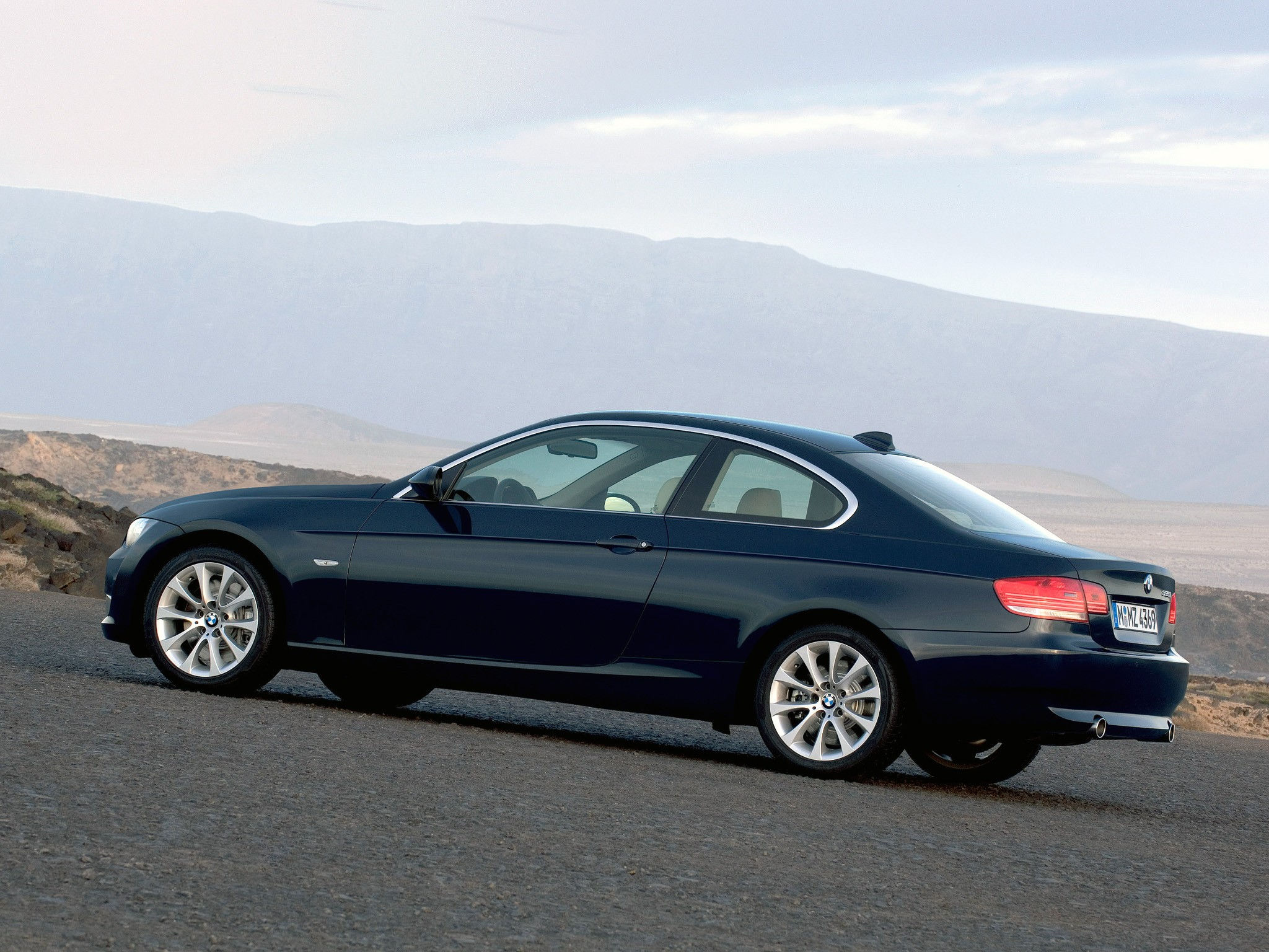 Wallpaper #lUW_oo4B7YBJg1BVBqSA34 A Sleek Black BMW 3-Series Coupe Drives Through a Mountainous Landscape