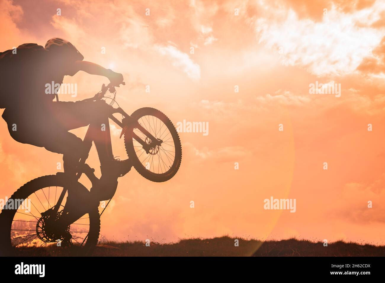 Wallpaper #OmfE85IBSpphPi3-wnd1314 Wheelie with E Bike with Sky on Fire at Sunset Hi Res Stock Photography