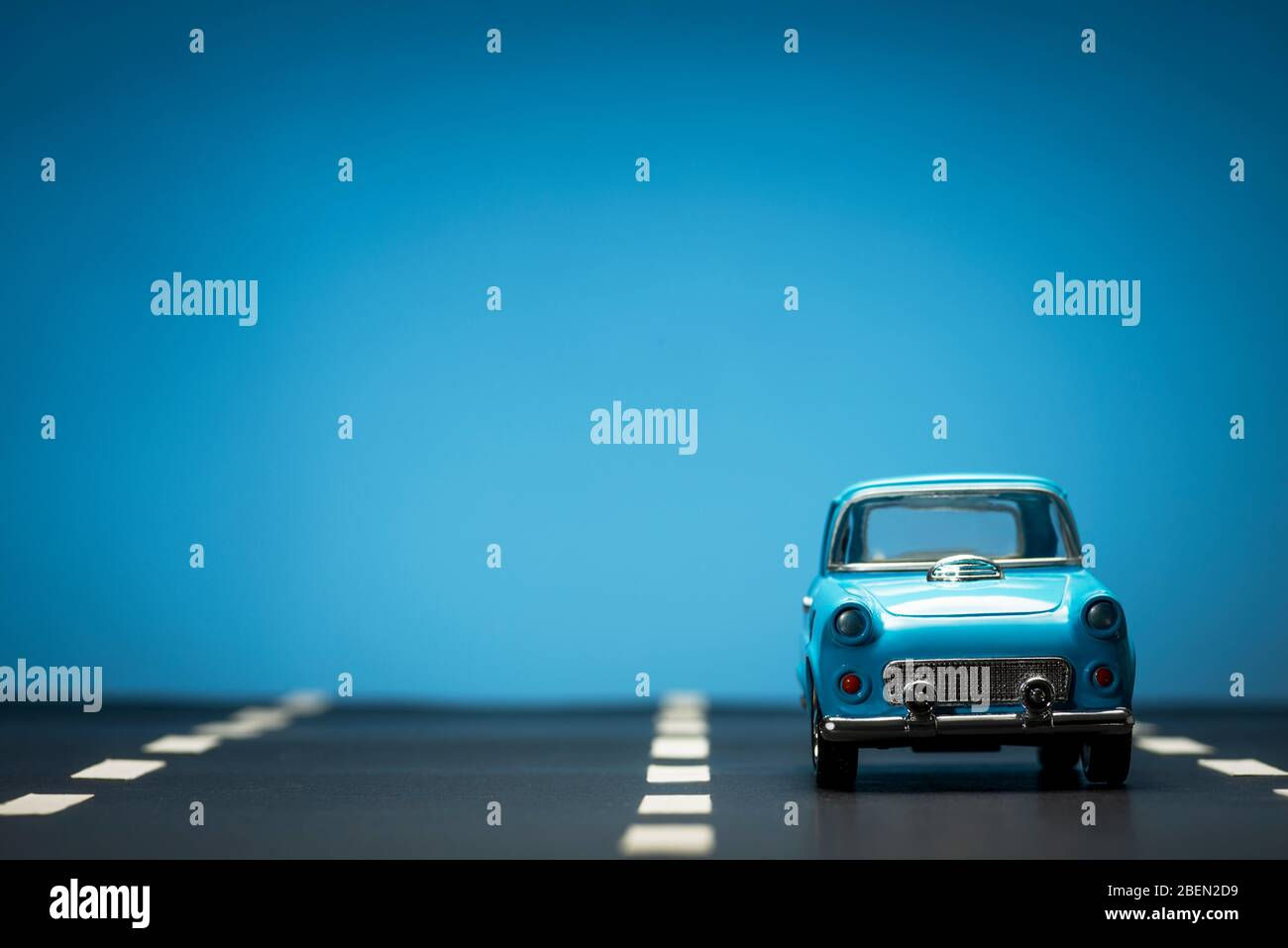 Wallpaper #0GfJ9pIBSpphPi3-OYTp206 Front View of a Blue Toy Car on on an Asphalt Road and a Blue