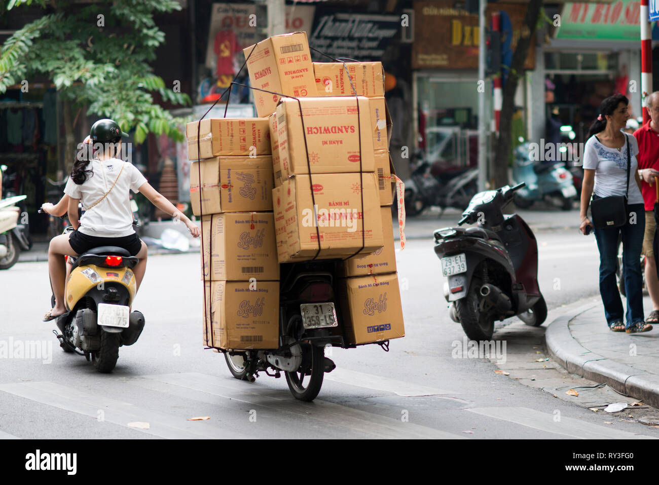 Wallpaper #82dECpMBSpphPi3-V9PH455 Man Carrying Boxes for Delivery on a Motorbike in a Street of Hanoi