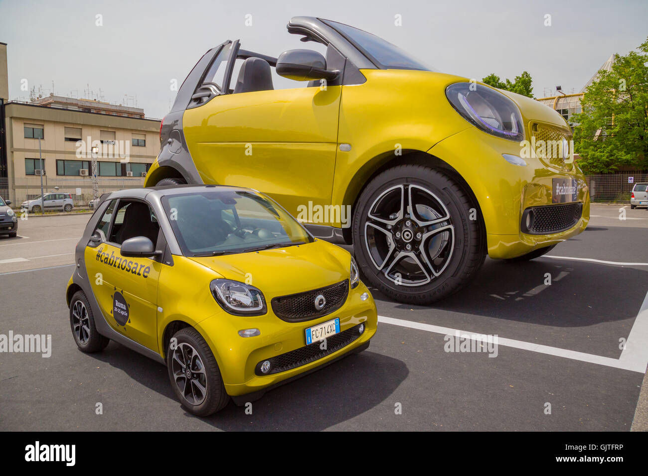 Wallpaper #dmdX_ZIBSpphPi3--Zv279 A Giant Smart Car Next to a Standard Size Smart Car in Rome Featuring