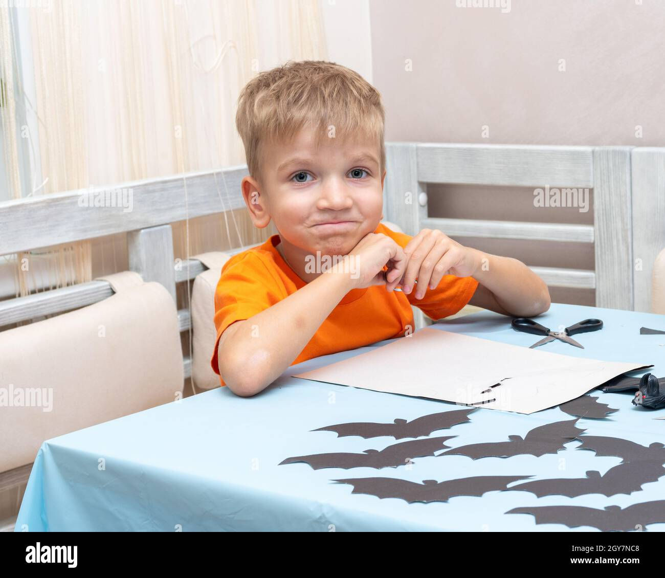 Wallpaper #lQMqZpMBpyOg8YnE0dqs300 A Boy Draws and Cuts a Halloween Decoration at Home from Black Paper