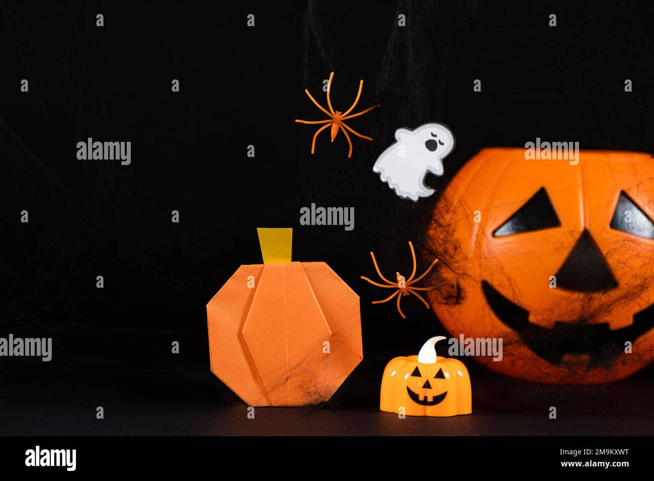 Wallpaper #g_RLOZMBKFX8bn3rLHYG283 Orange Pumpkins a Ghost Spiders and Spider Webs on a Black Background