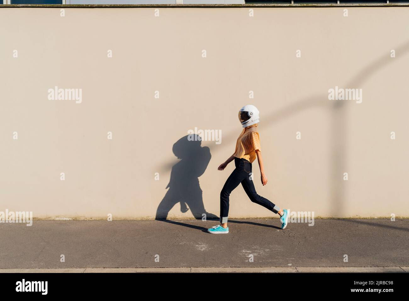 Wallpaper #2BGgM5MBXrlMTfB5u0qk243 Woman Wearing Space Helmet Walking by Beige Wall Stock Photo Alamy