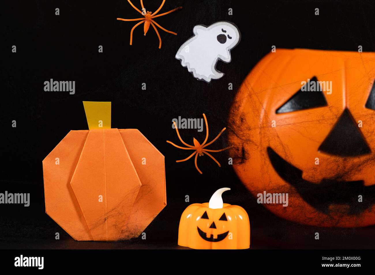 Wallpaper #g_RLOZMBKFX8bn3rLHYG268 Orange Pumpkins a Ghost Spiders and Spider Webs on a Black Background