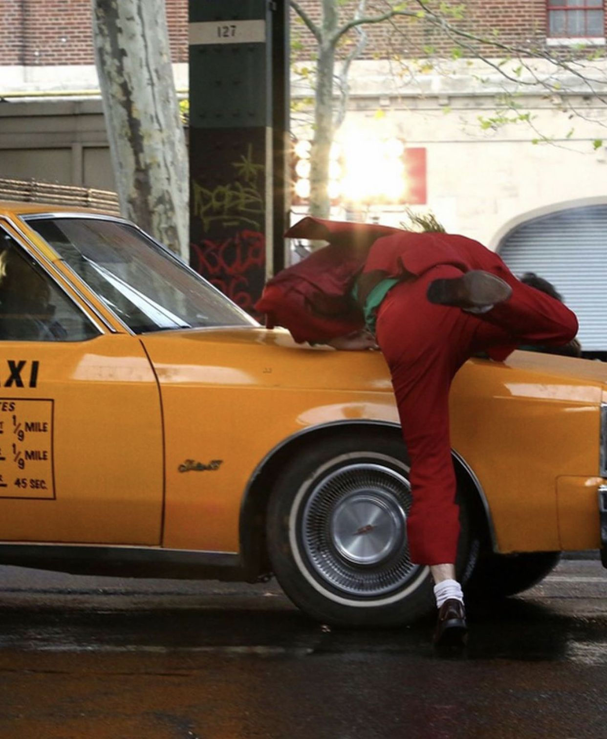 Wallpaper #_0C5MZMBJhL2WPbay8f5328 A Person Leaning on the Hood of a Yellow Taxi