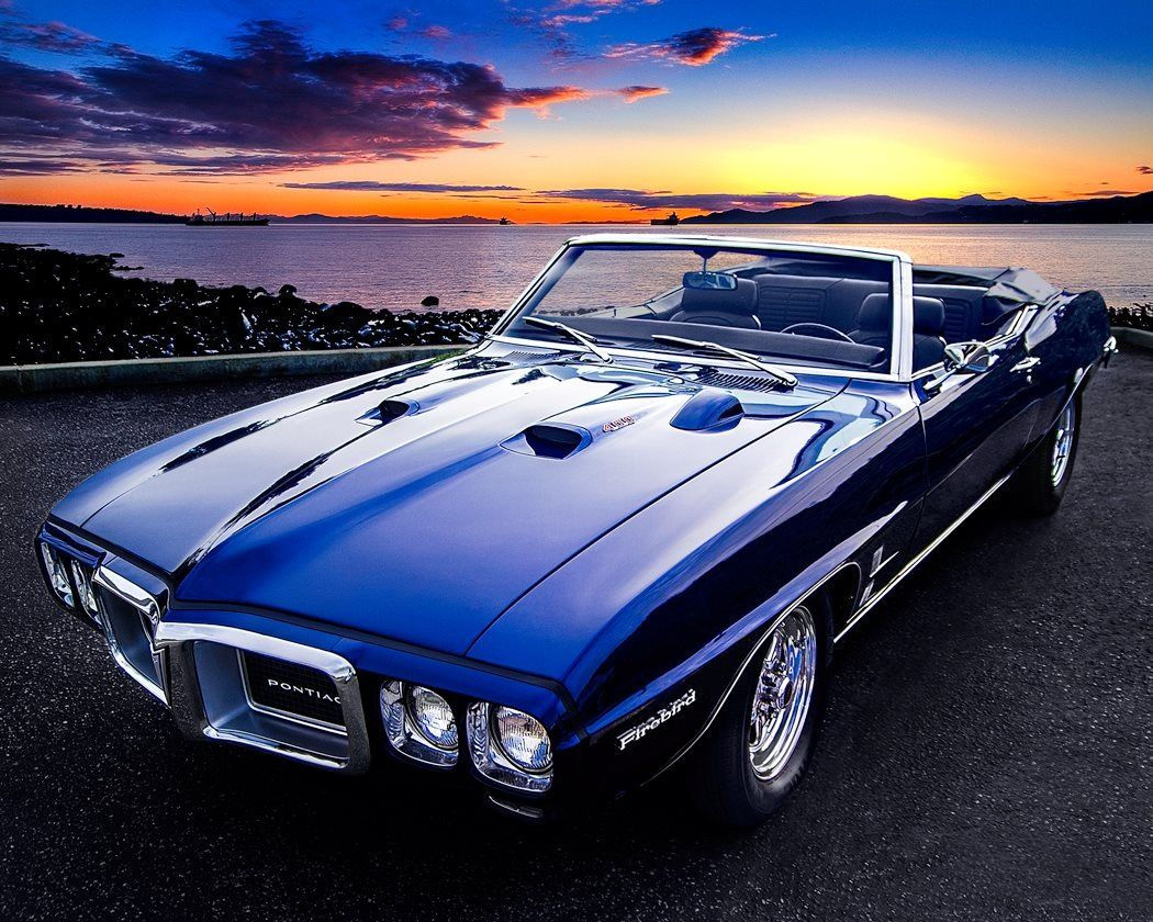 Wallpaper #KpyZ4pIBZHQxiYarYME5282 A Classic Muscle Car Parked in Front of the Ocean at Sunset or Dawn