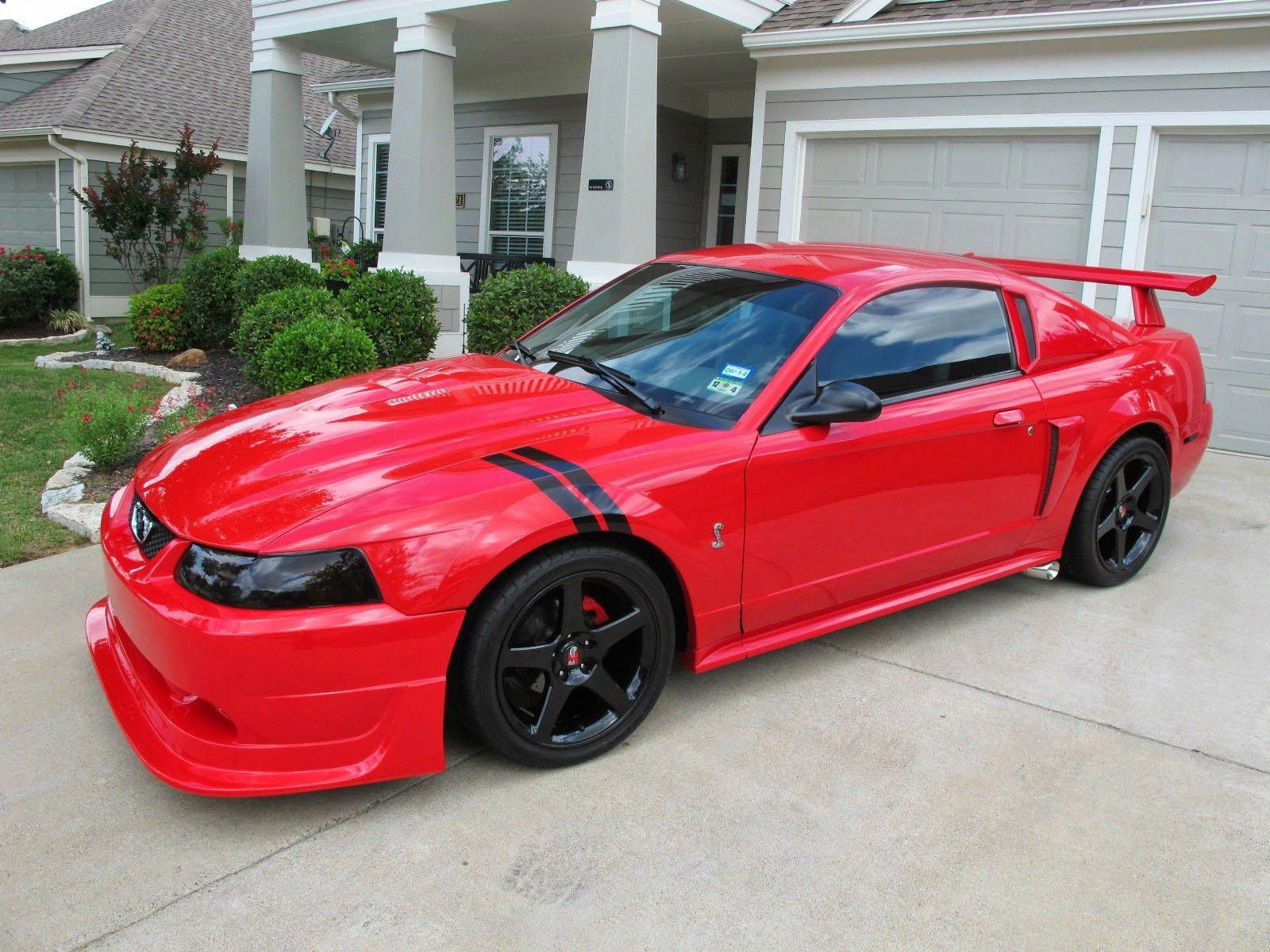 Wallpaper #CUV-jo4B7YBJg1BVkJ2n46 A Red Ford Mustang Svt Cobra Parked in Front of a House