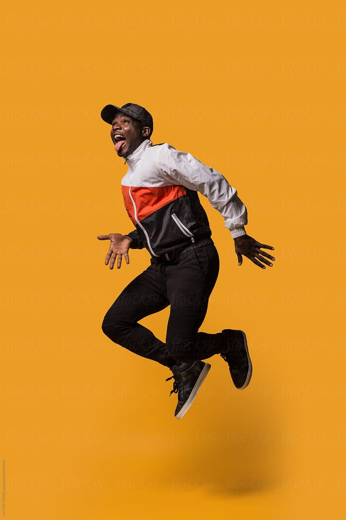 Wallpaper #vQMhY5MBpyOg8YnExNQw235 Stylish Sporty Man Jumping Over a Yellow Background by Stocksy