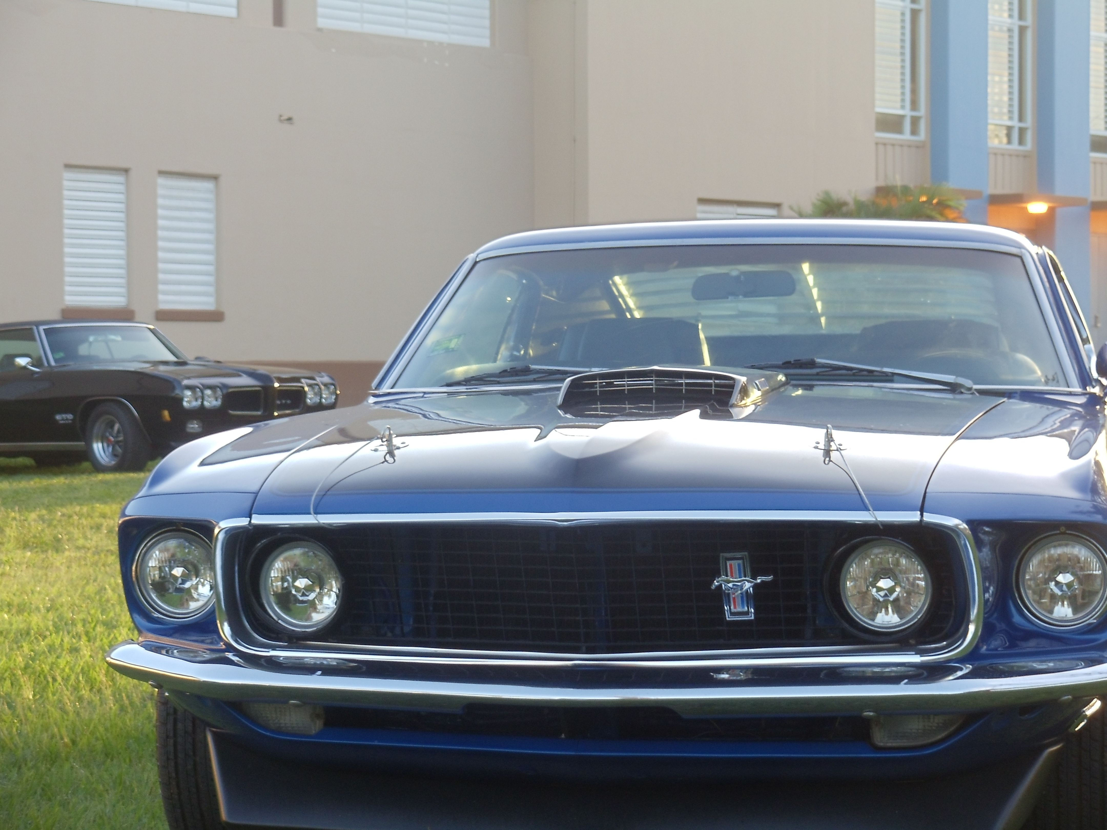 Wallpaper #vUUBm44B7YBJg1BVD6GI26 A Blue Ford Mustang Mach 1 Parked Next to a Black Pontiac Gto