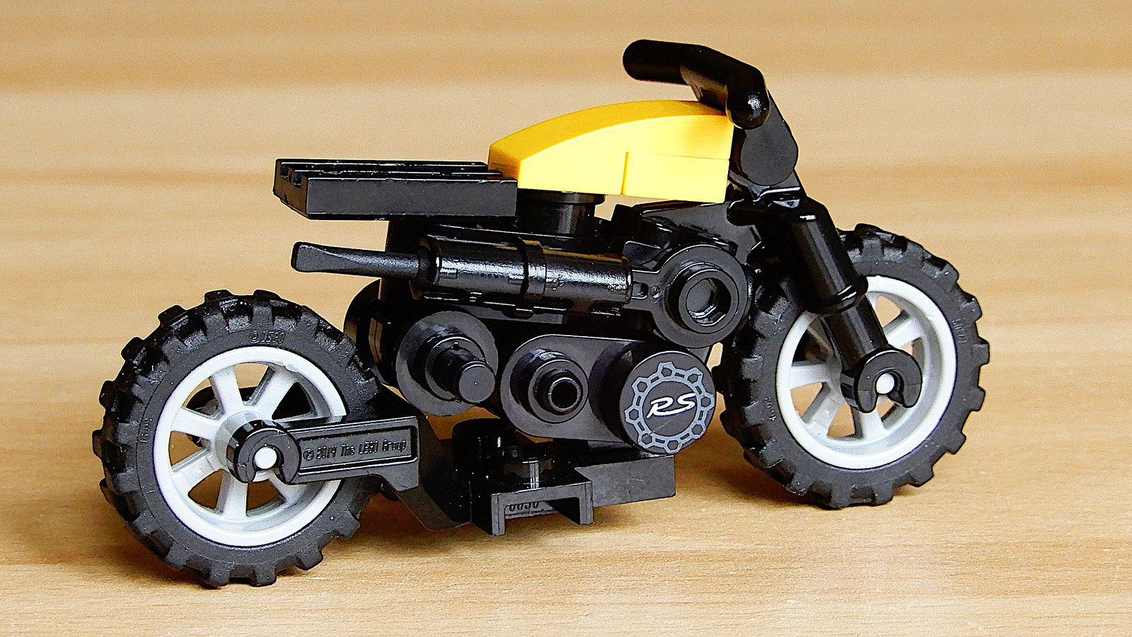 Wallpaper #HxncLI8BtGB6xQ78p5H429 A Toy Motorcycle Made Out of Legos on a Wooden Table with White Wheels