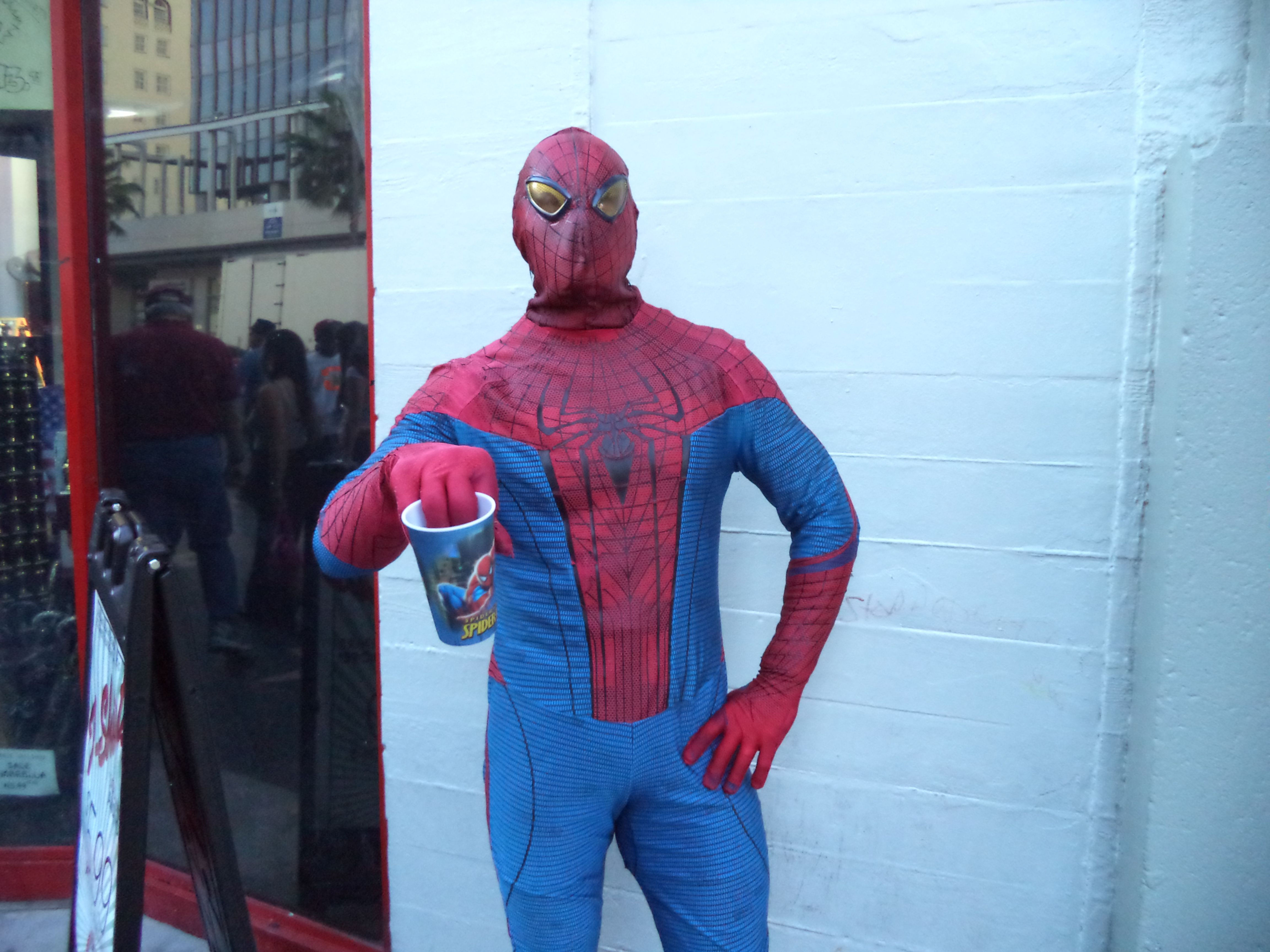 Wallpaper #VxlJDo8BtGB6xQ78sllp52 A Man in a Spiderman Costume Holding a Cup and Standing Next to a Building