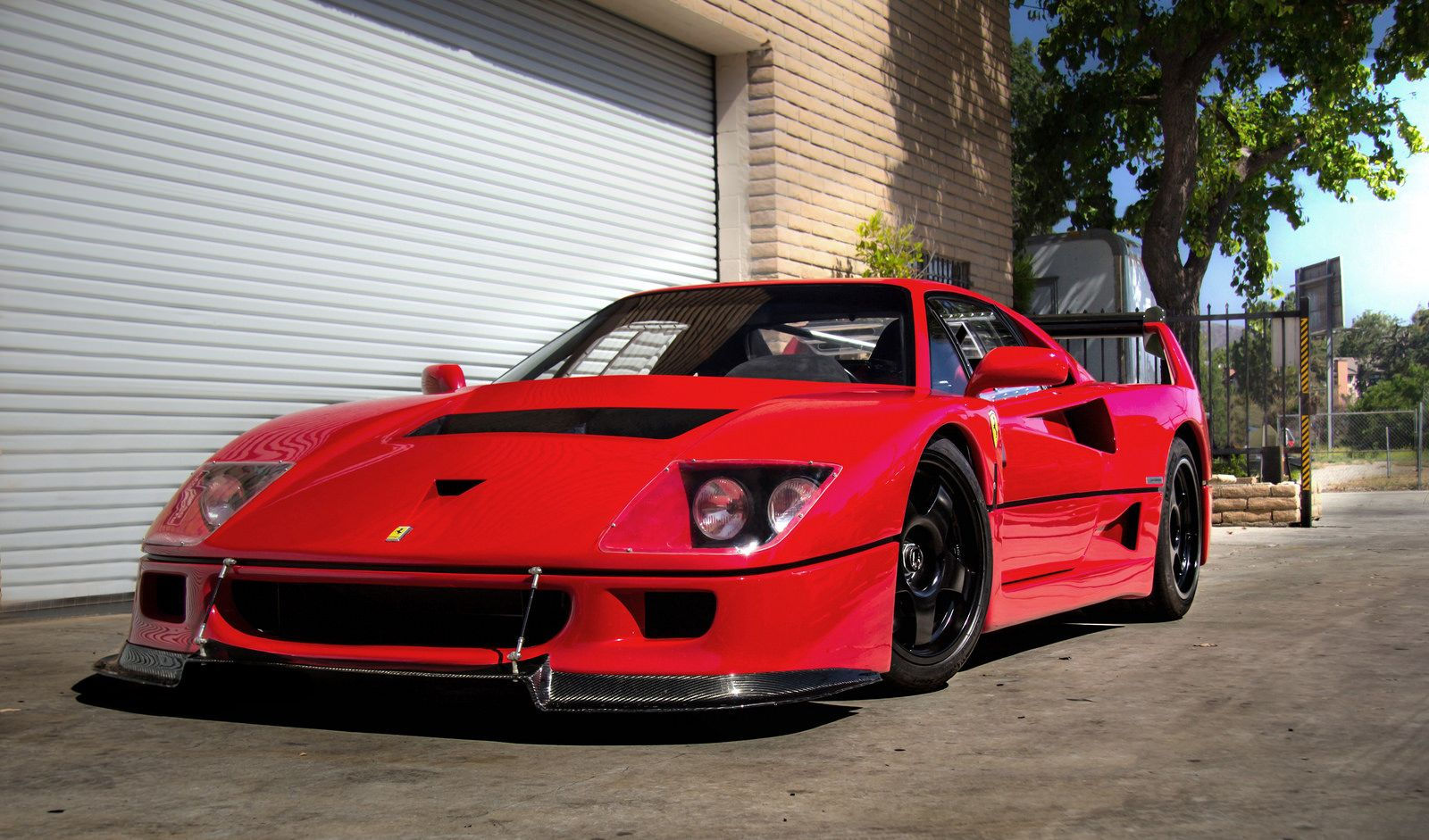 Wallpaper #K3OBh44BFI5NbQksaSEI6 A Sleek Red Ferrari F40 Parked in Front of a Garage