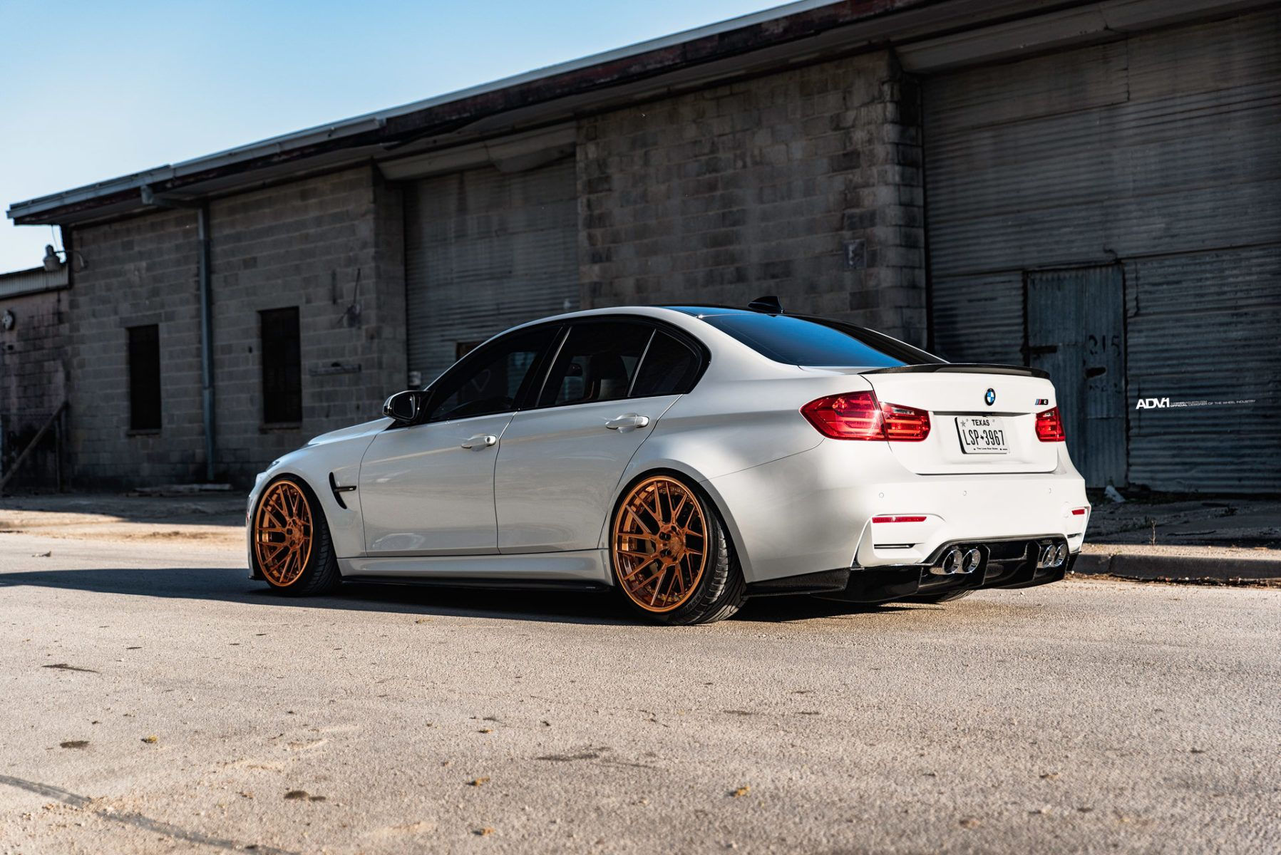 Wallpaper #QRU3t44BmMigT4Un71TH50 A White BMW M3 with Bronze Wheels Parked in an Urban Setting