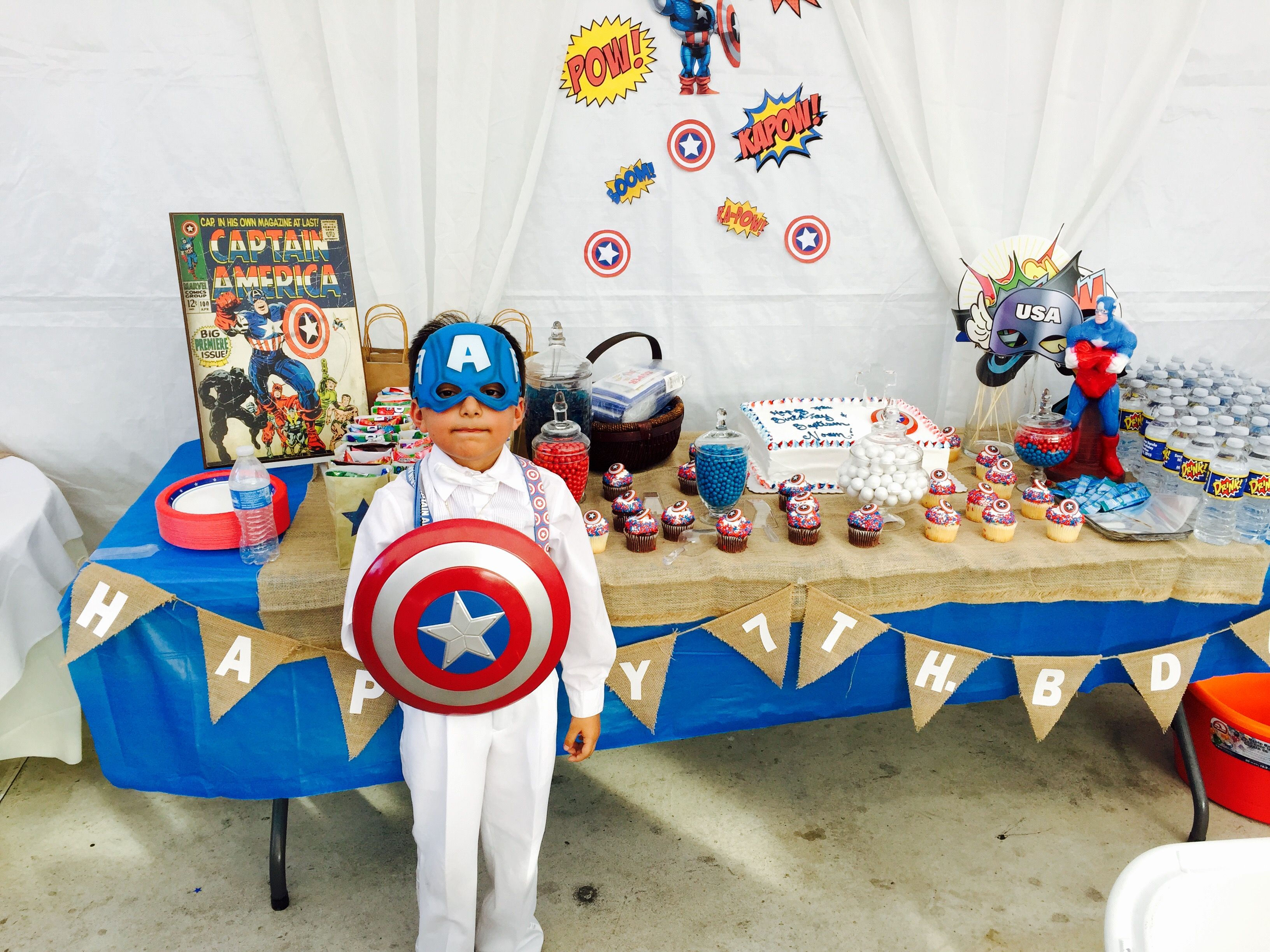 Wallpaper #THPrgo4BFI5NbQkszxmX35 A Young Boy Dressed as Captain America Stands in Front of a Table Decorated with Captain America Themed Items