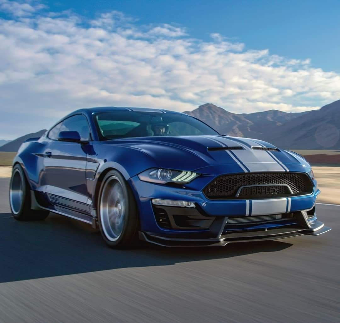 Wallpaper #9ho2UJMB1yWOL4qgrn_E53 A Blue Mustang is Driving Down the Road