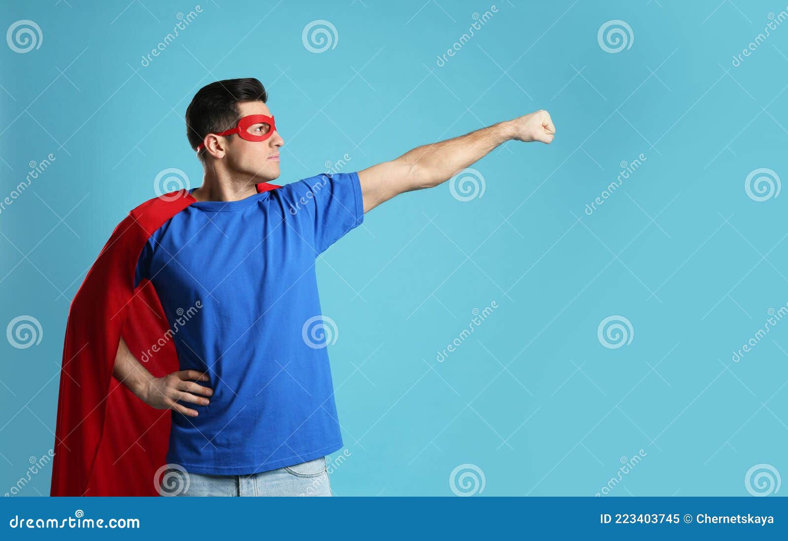 Wallpaper #m2fSBJMBSpphPi3-n7nR61 Man Wearing Superhero Cape and Mask on Light Blue Background Stock