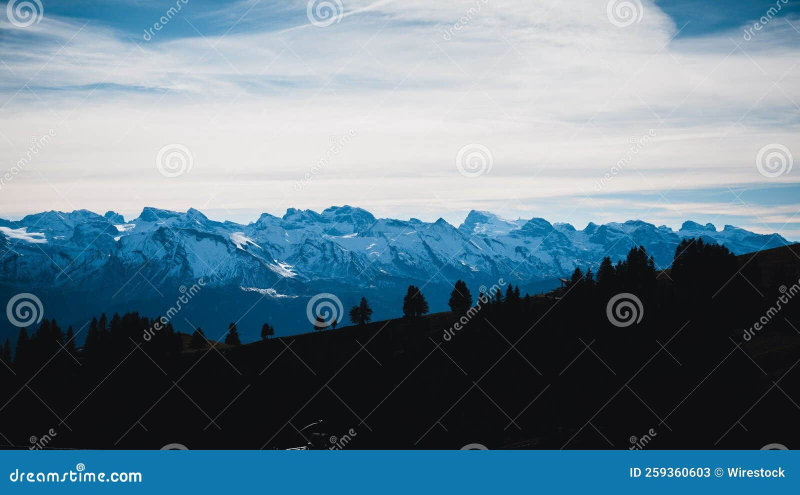 Wallpaper #x--qS5MBMN-XEVvVnztn174 Snowy Mountain Range with Tree Silhouettes Cloudy Sky Background Stock