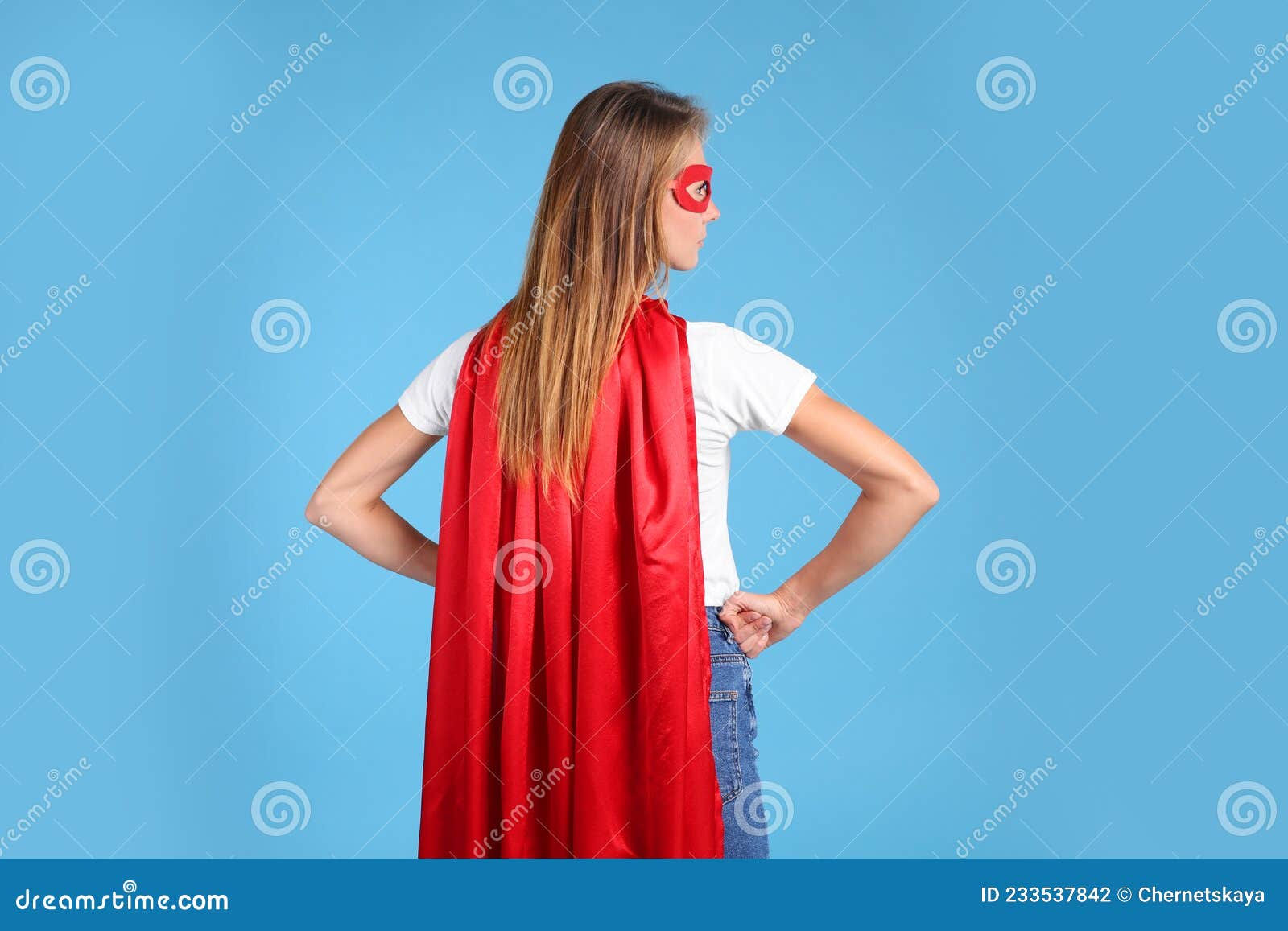 Wallpaper #m2fSBJMBSpphPi3-n7nR67 Woman Wearing Superhero Cape and Mask on Light Blue Background Back