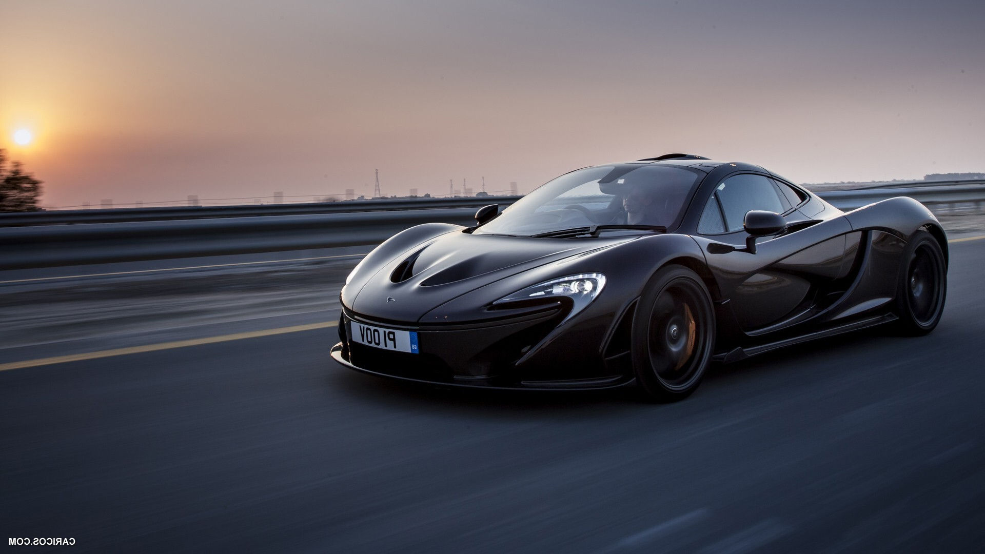 Wallpaper #0nP5hY4BFI5NbQksux4v5 A Black Mclaren P1 Driving on an Open Road at Sunset