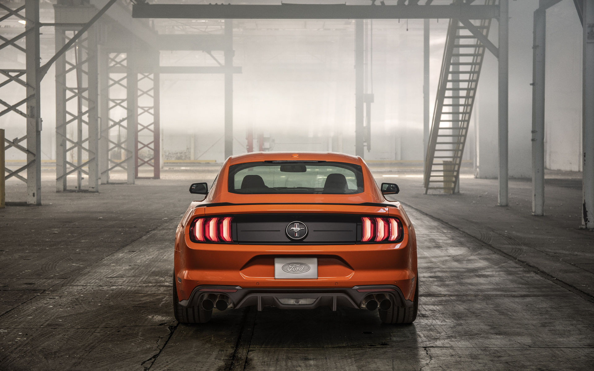Wallpaper #_kWjoY4B7YBJg1BVvqN849 A Sleek Orange Ford Mustang Parked in an Industrial Setting