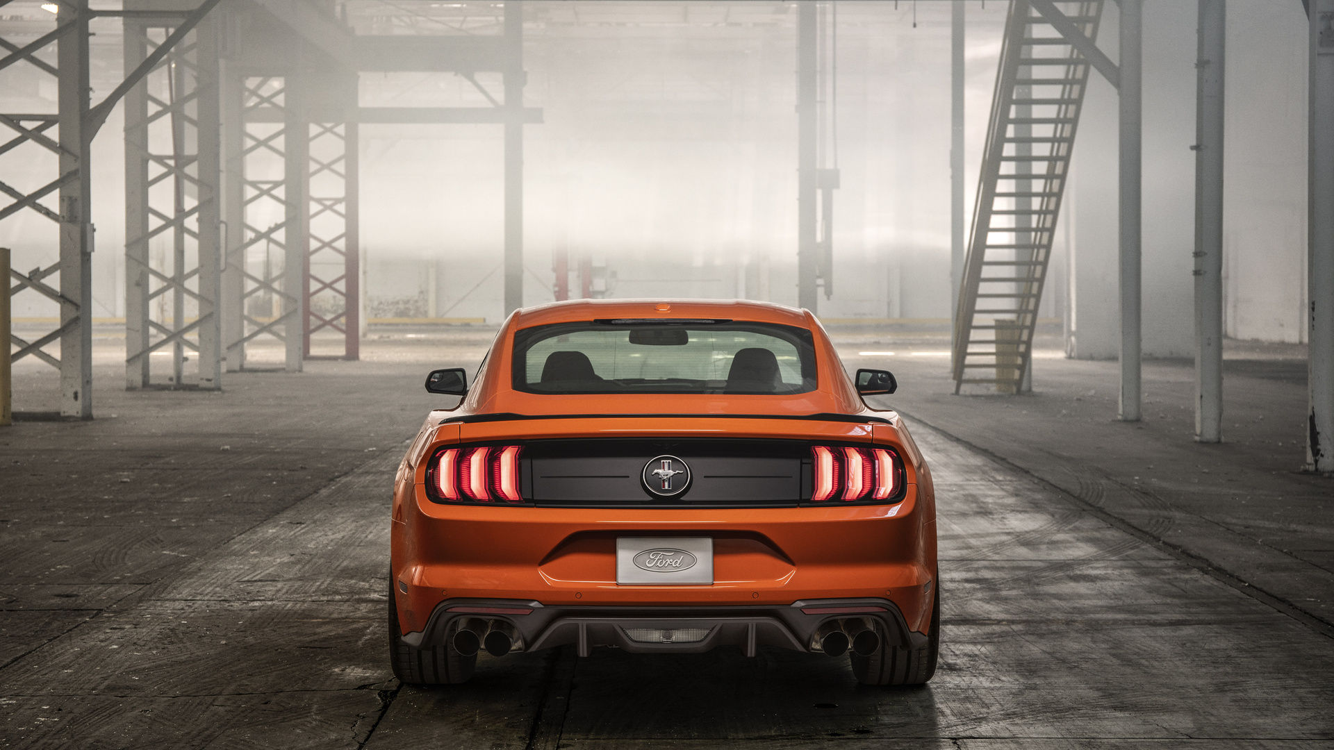 Wallpaper #_kWjoY4B7YBJg1BVvqN847 A Sleek Orange Ford Mustang Parked in an Industrial Setting