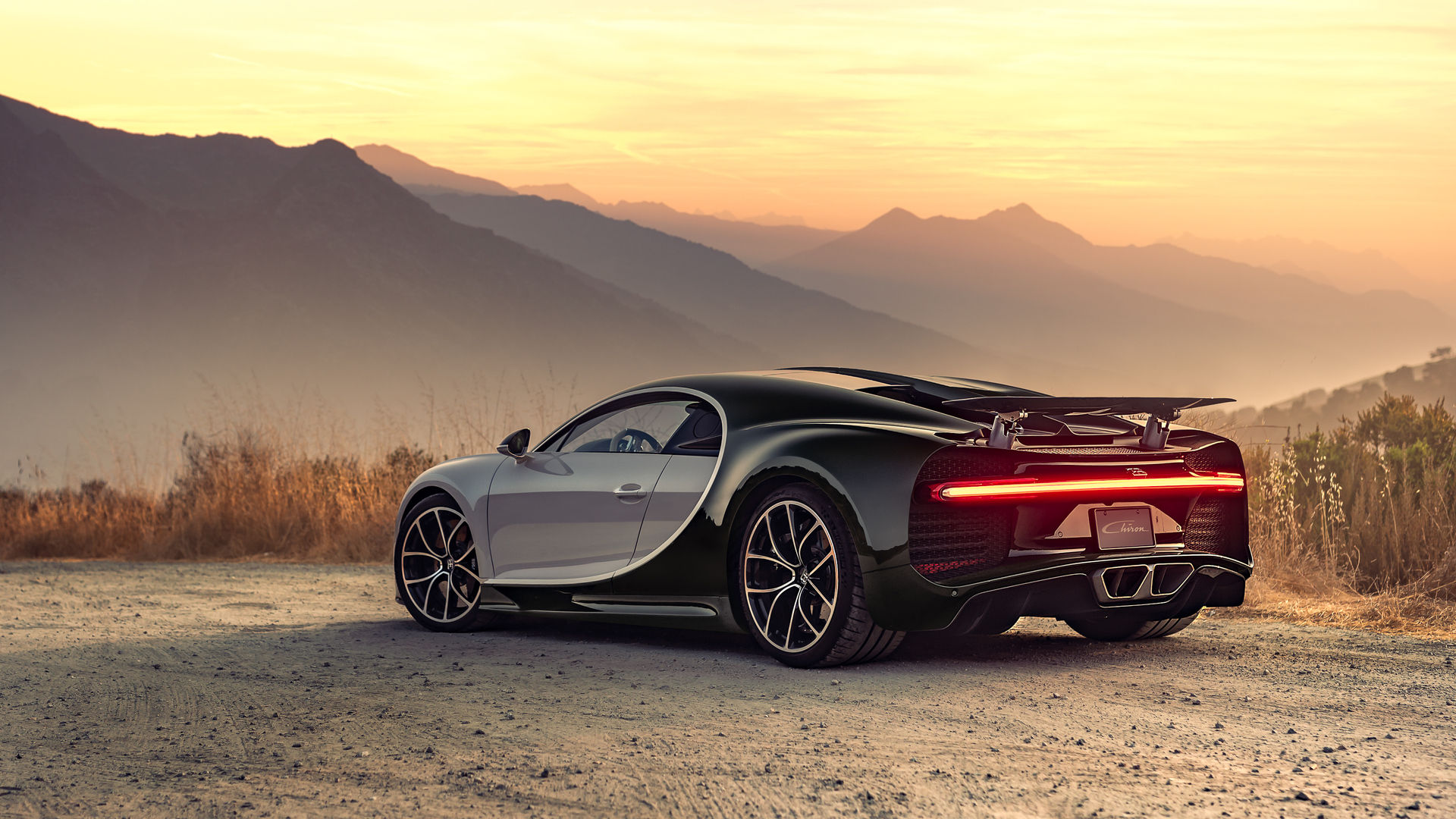 Wallpaper #6HOoiI4BFI5NbQksoSFu51 A Hypercar Drives Through a Mountainous Landscape at Sunset