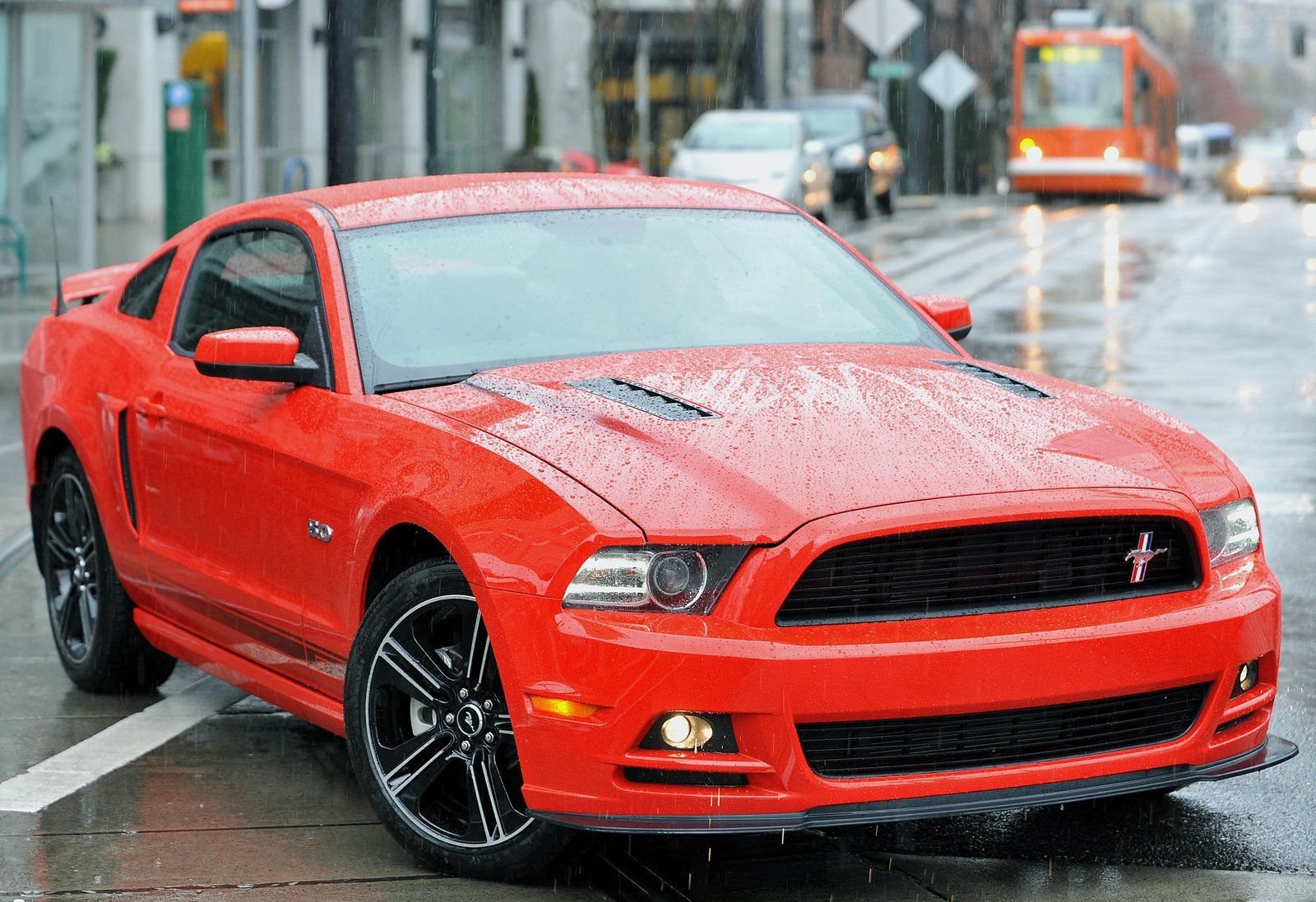 Wallpaper #vUUBm44B7YBJg1BVD6GI29 A Red Ford Mustang Parked on a City Street in the Rain