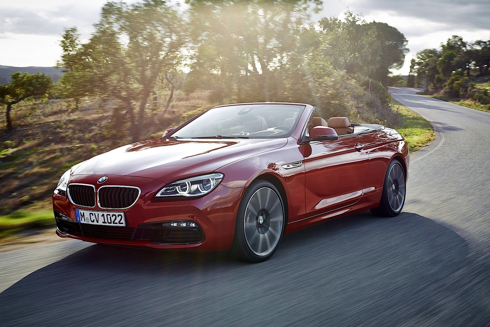 Wallpaper #VkVolo4B7YBJg1BVLqAC28 A Red BMW 6 Series Convertible Driving on a Winding Road