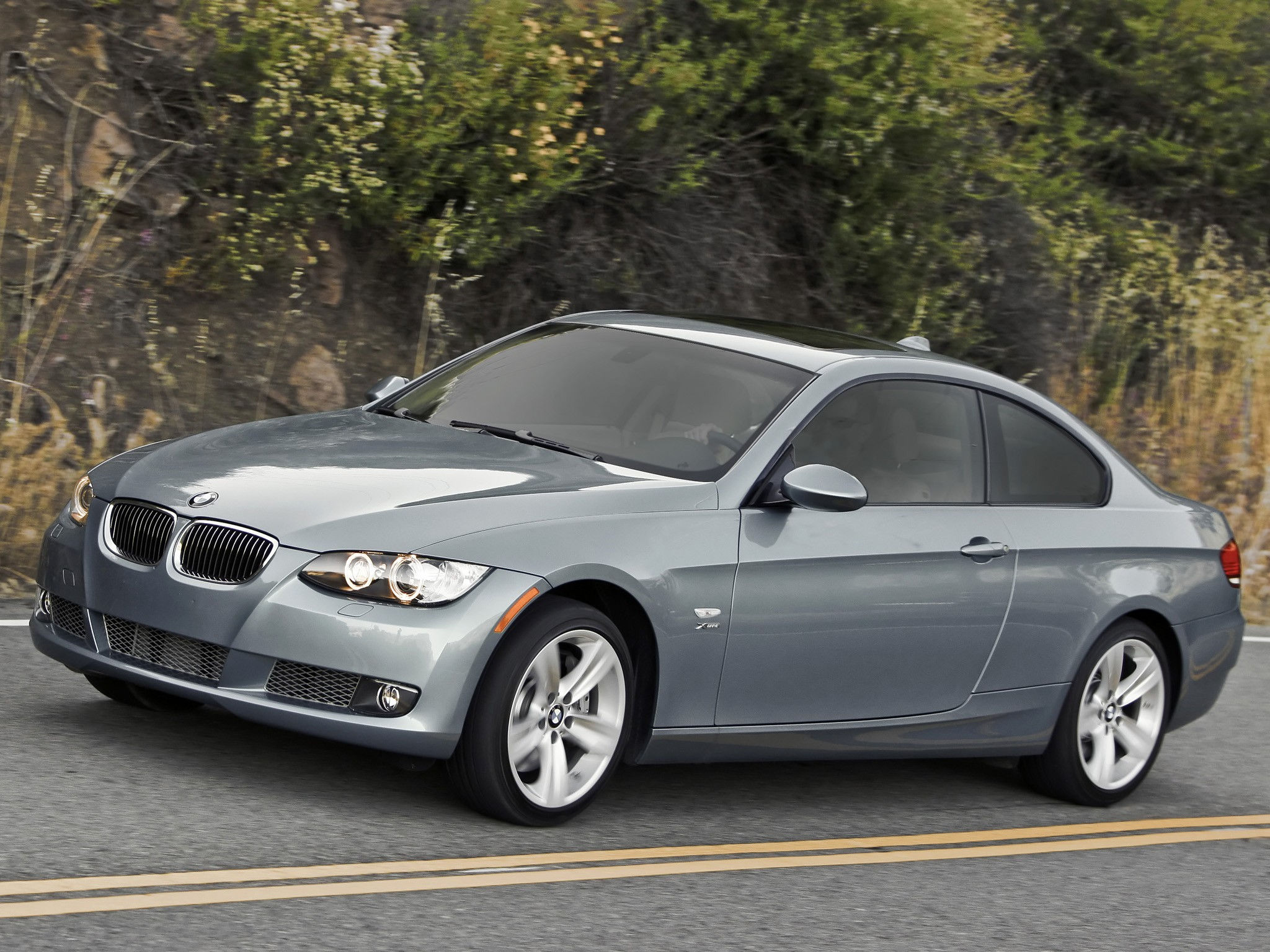 Wallpaper #lUW_oo4B7YBJg1BVBqSA21 A Sleek Silver BMW 335i Coupe Drives on a Winding Road