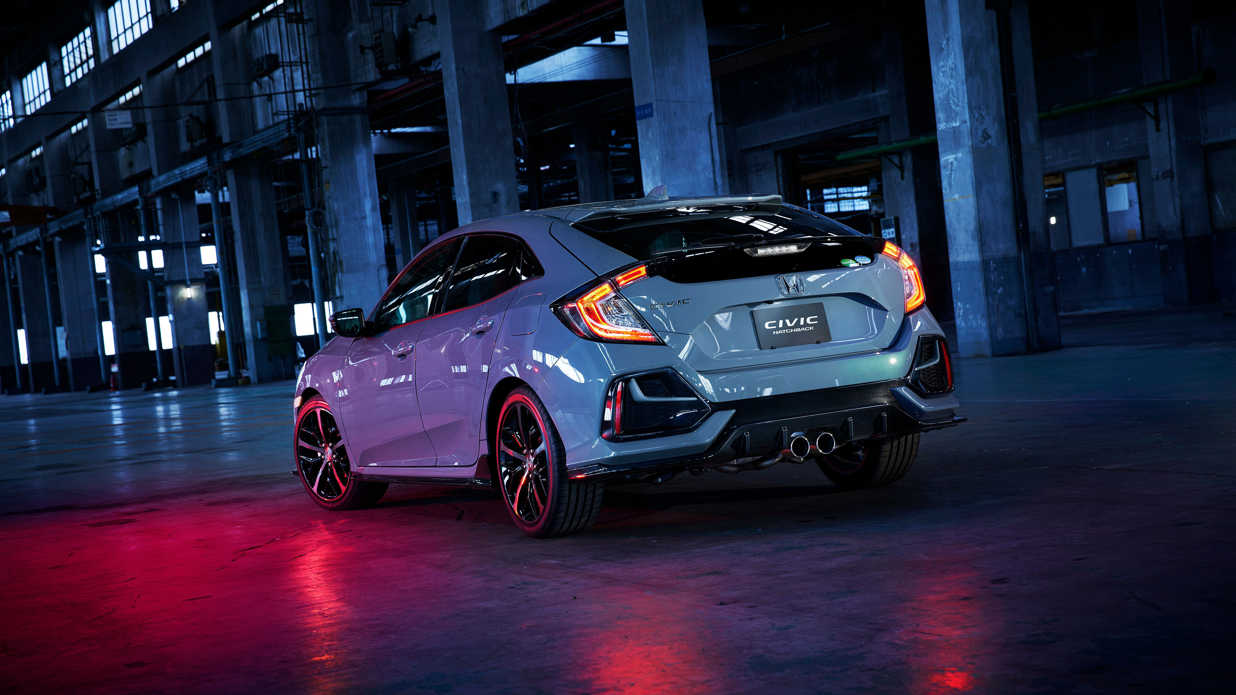 Wallpaper #r0U0l44B7YBJg1BVZKDq1 A Sporty Gray 2020 Honda Civic Hatchback Parked in an Industrial Building with Red Lighting
