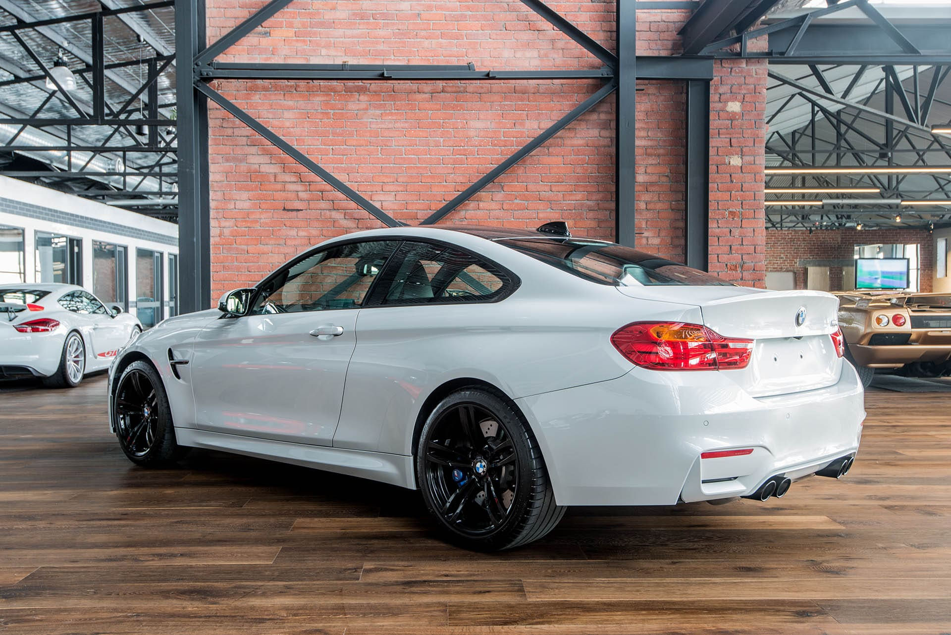 Wallpaper #wnMuiI4BFI5NbQksECES20 A Sleek White BMW M4 Parked in a Showroom