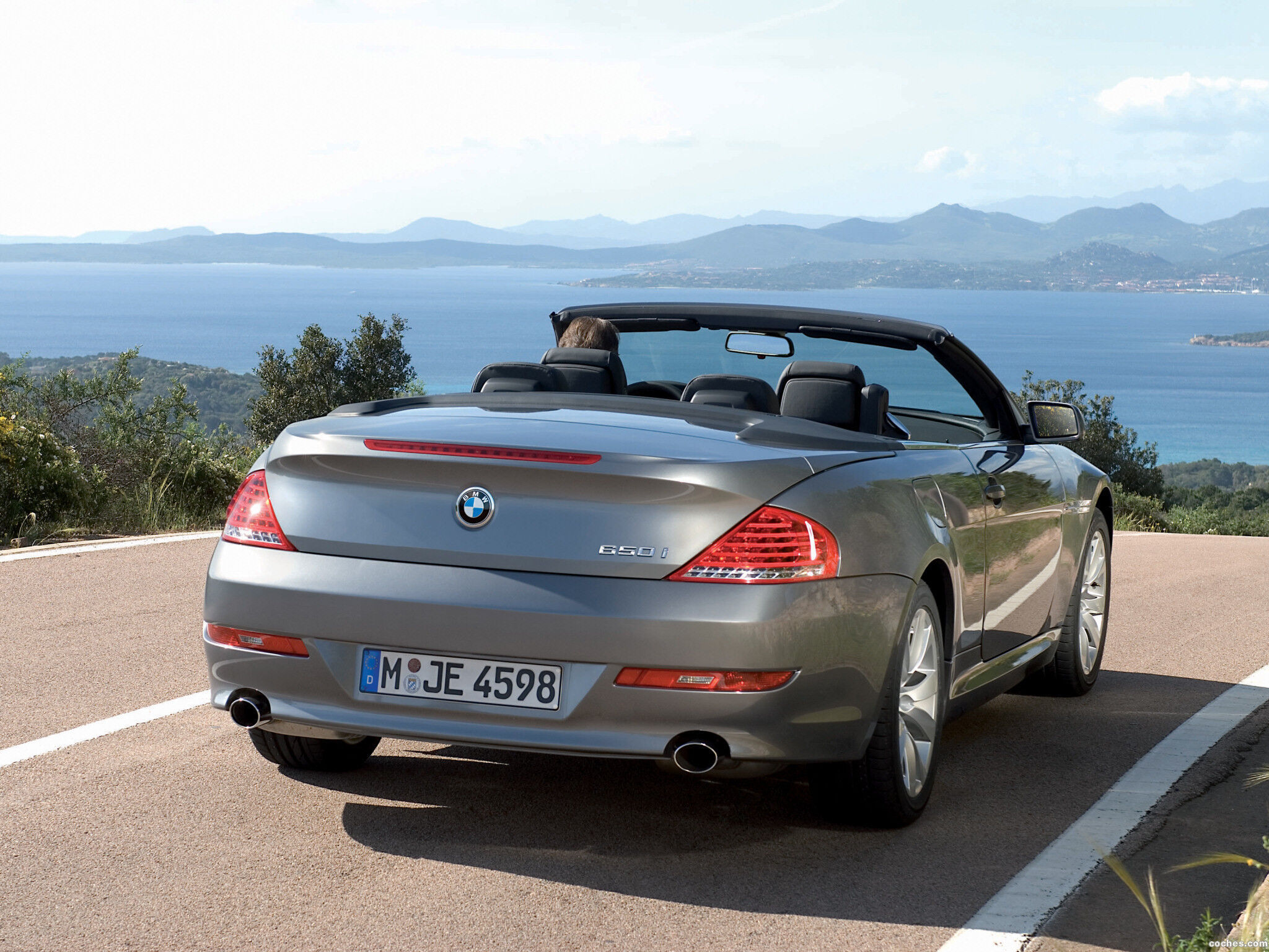 Wallpaper #VkVolo4B7YBJg1BVLqAC29 A Silver BMW 6 Series Convertible Driving on a Coastal Road with the Top Down