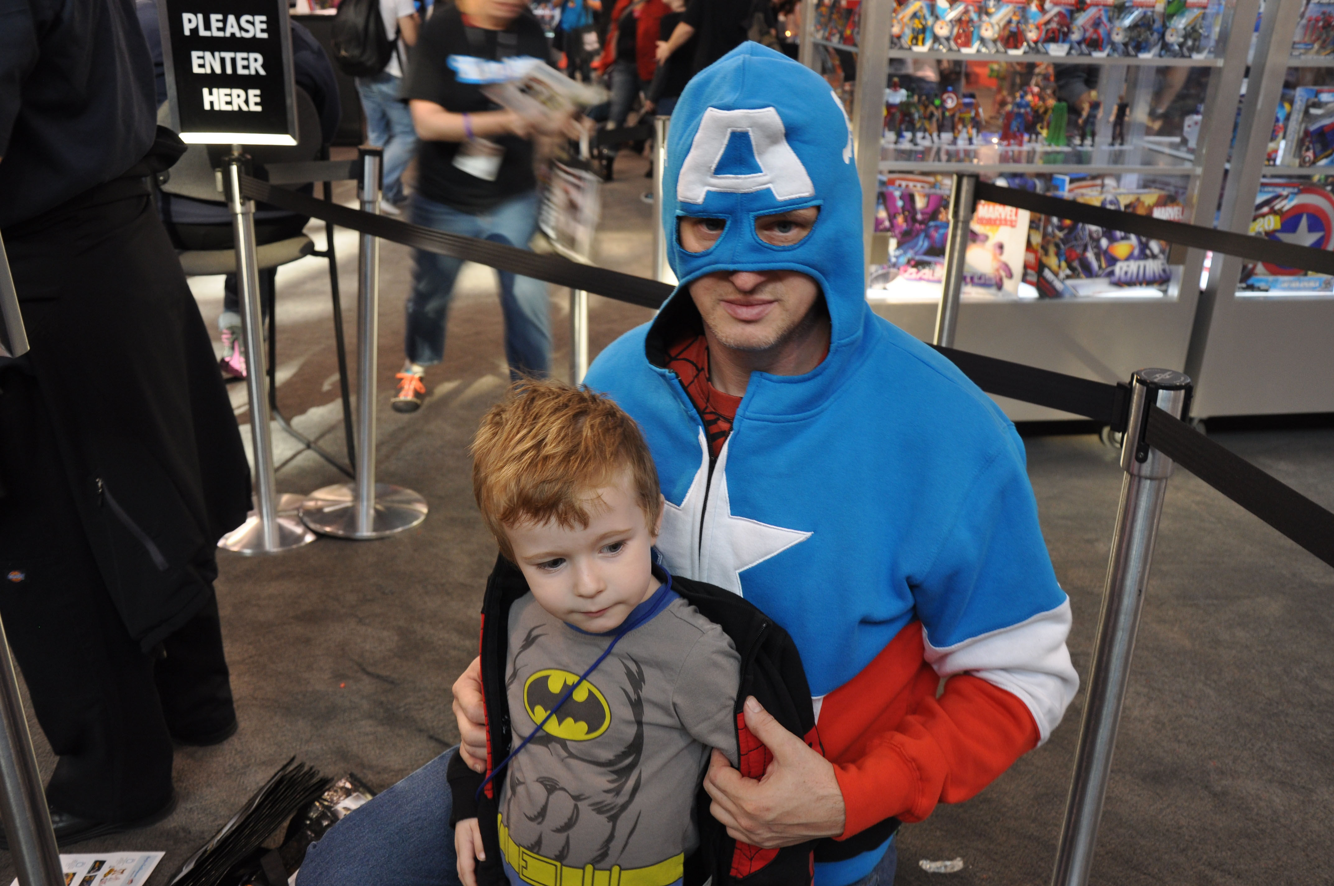 Wallpaper #UkUjno4B7YBJg1BVo6IZ43 A Father and Son Dressed as Captain America and Batman at a Convention