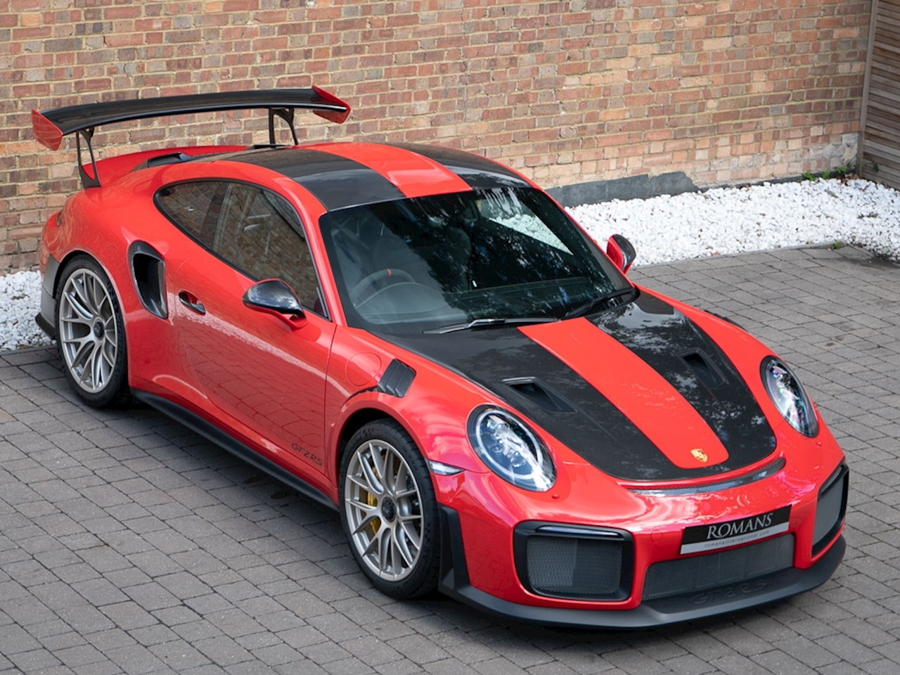Wallpaper #5HOrg44BFI5NbQks7BuT58 A Red and Black Porsche 911 Gt2 Rs Parked in Front of a Brick Building
