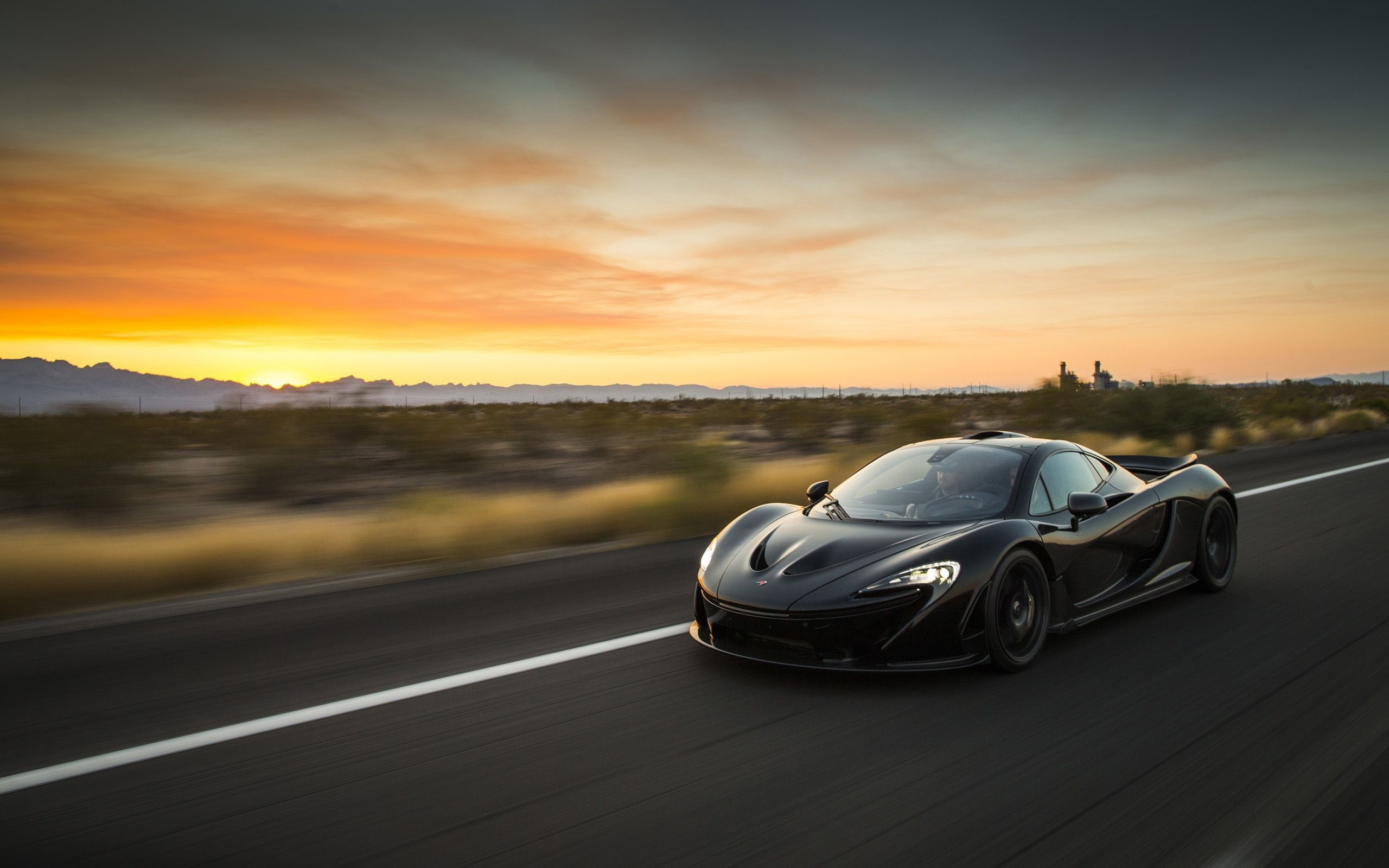 Wallpaper #0nP5hY4BFI5NbQksux4v16 A Black Mclaren P1 Driving on an Open Road at Sunset