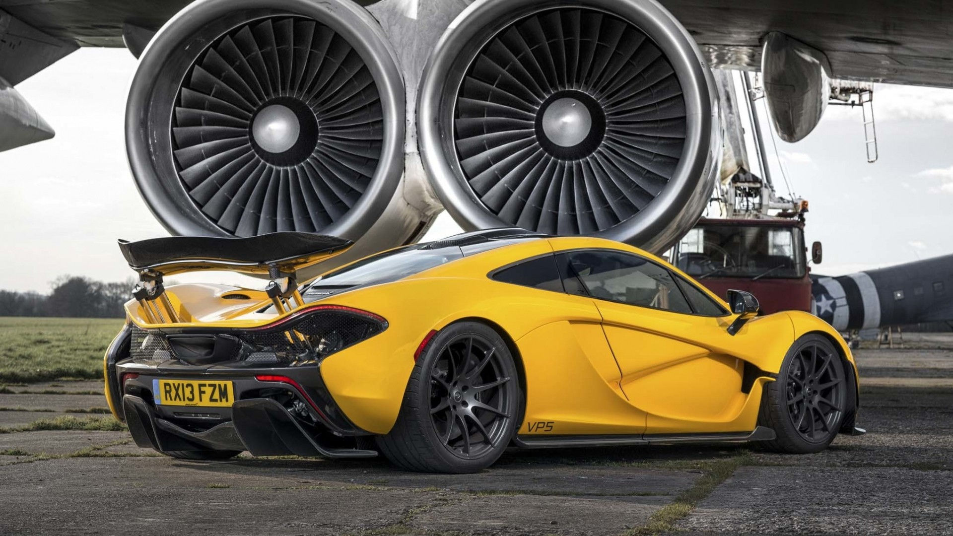 Wallpaper #0nP5hY4BFI5NbQksux4v57 A Yellow Mclaren P1 Parked in Front of a Jet Engine