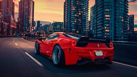 Wallpaper #YnP0fo4BFI5NbQksIxfN50 A Red Ferrari 458 Italia Driving Through a City at Sunset