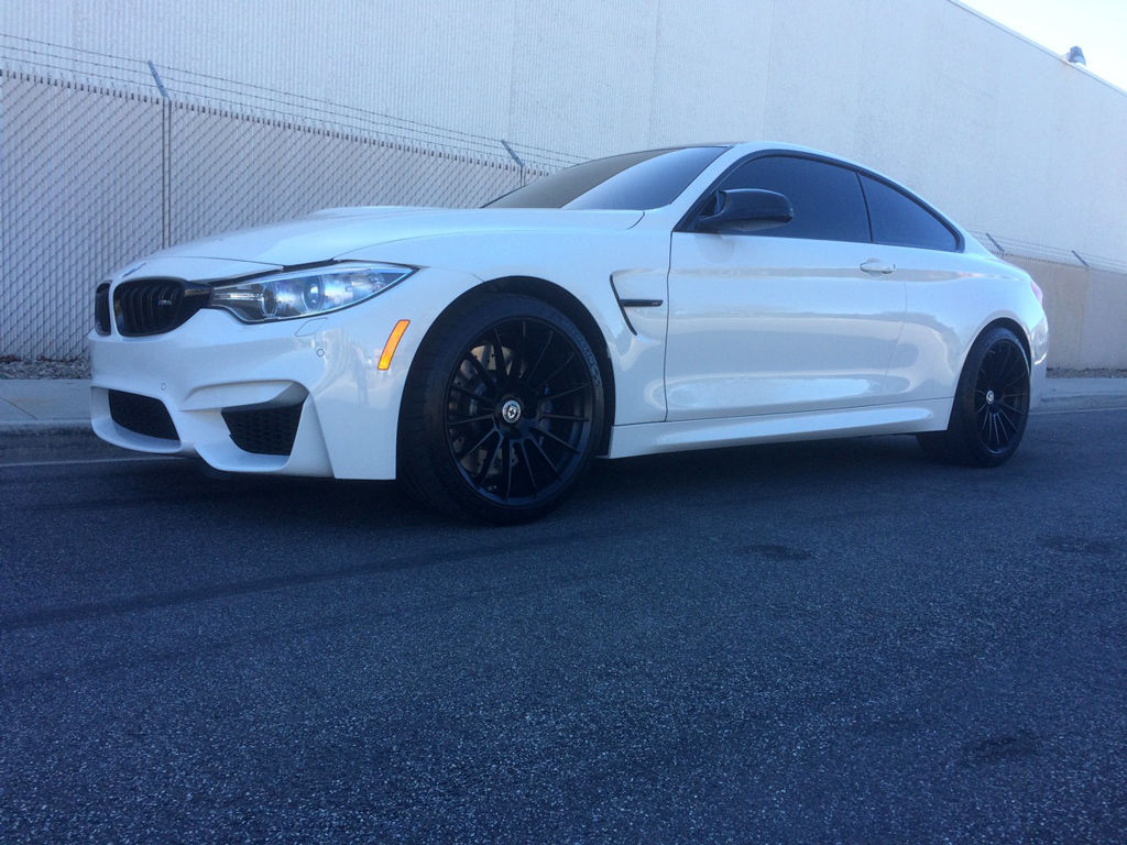 Wallpaper #wnMuiI4BFI5NbQksECES50 A Sleek White BMW M4 Parked on the Street